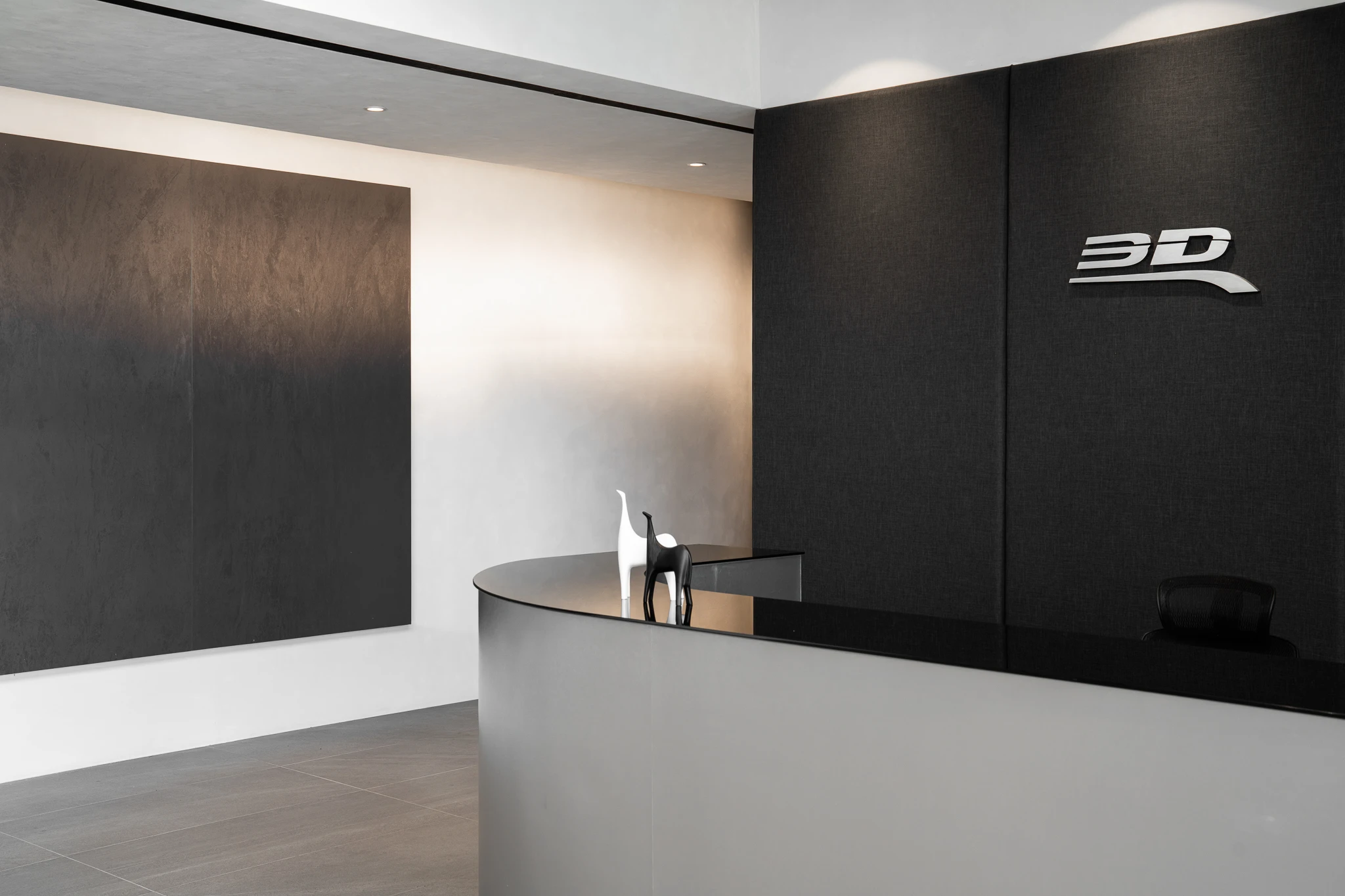 Curved reception desk against a dark logo wall