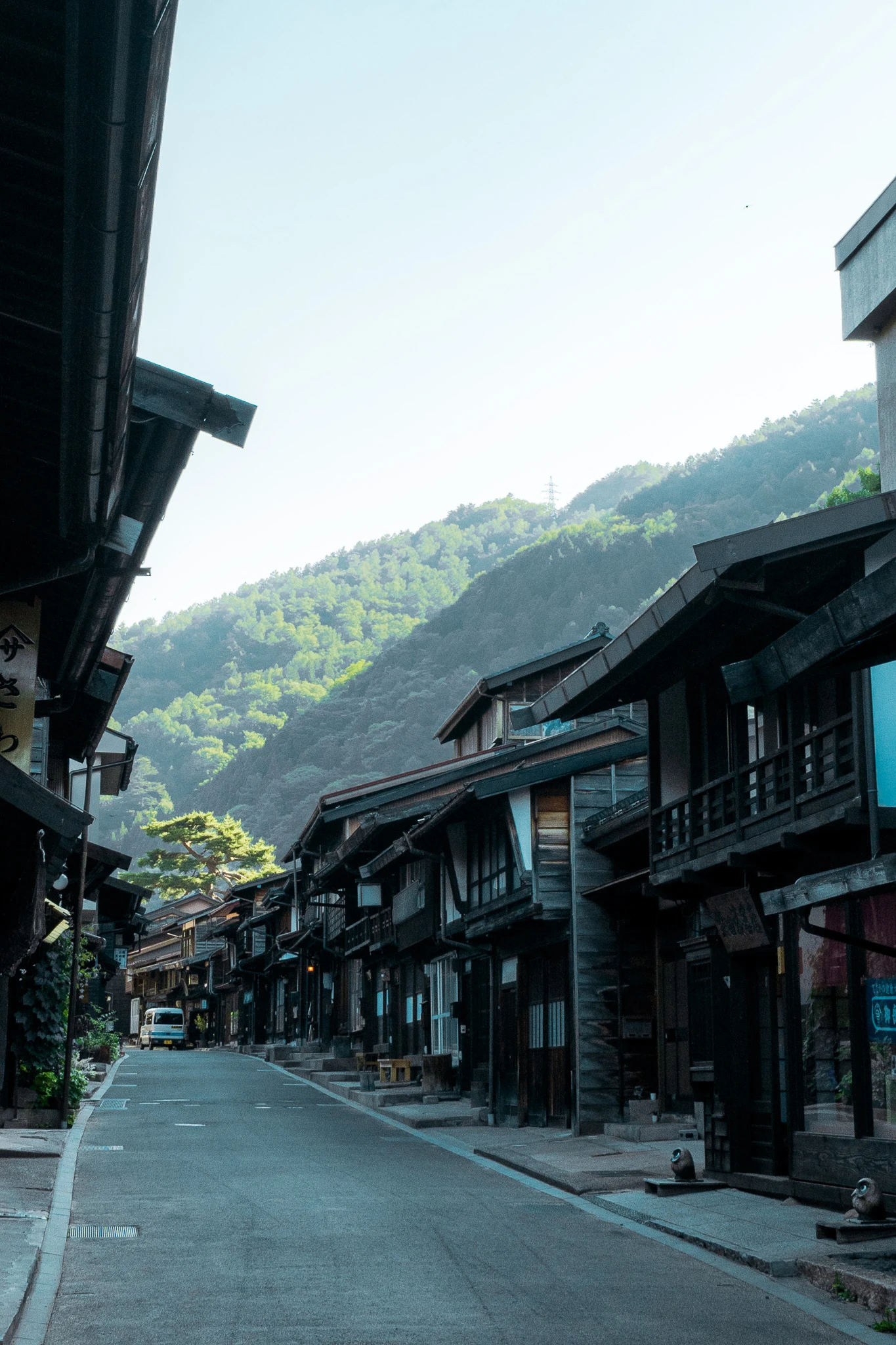 Quiet street lined with timber houses and distant hills
