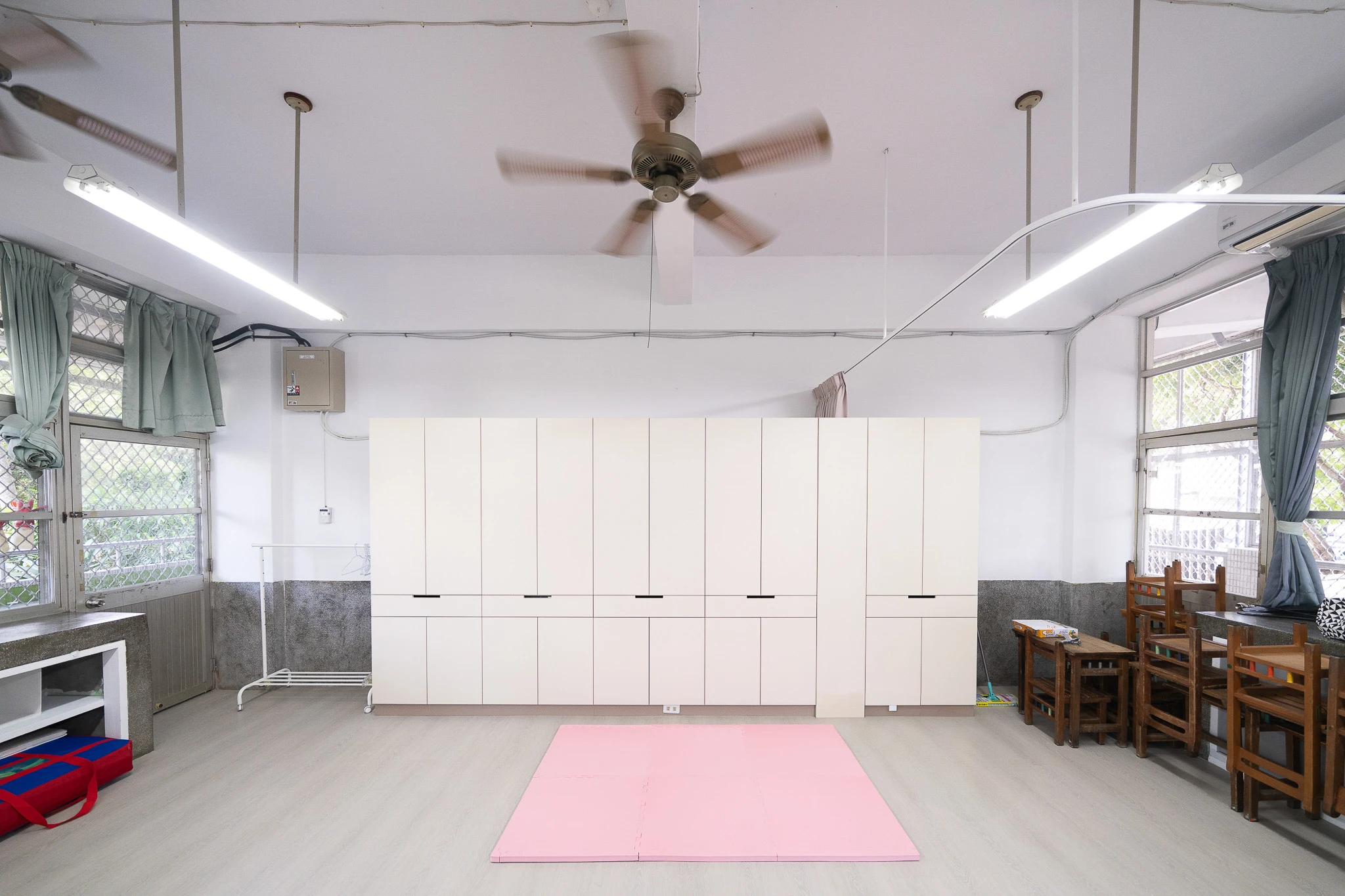 Renovated classroom with pale storage cabinets and an open floor area