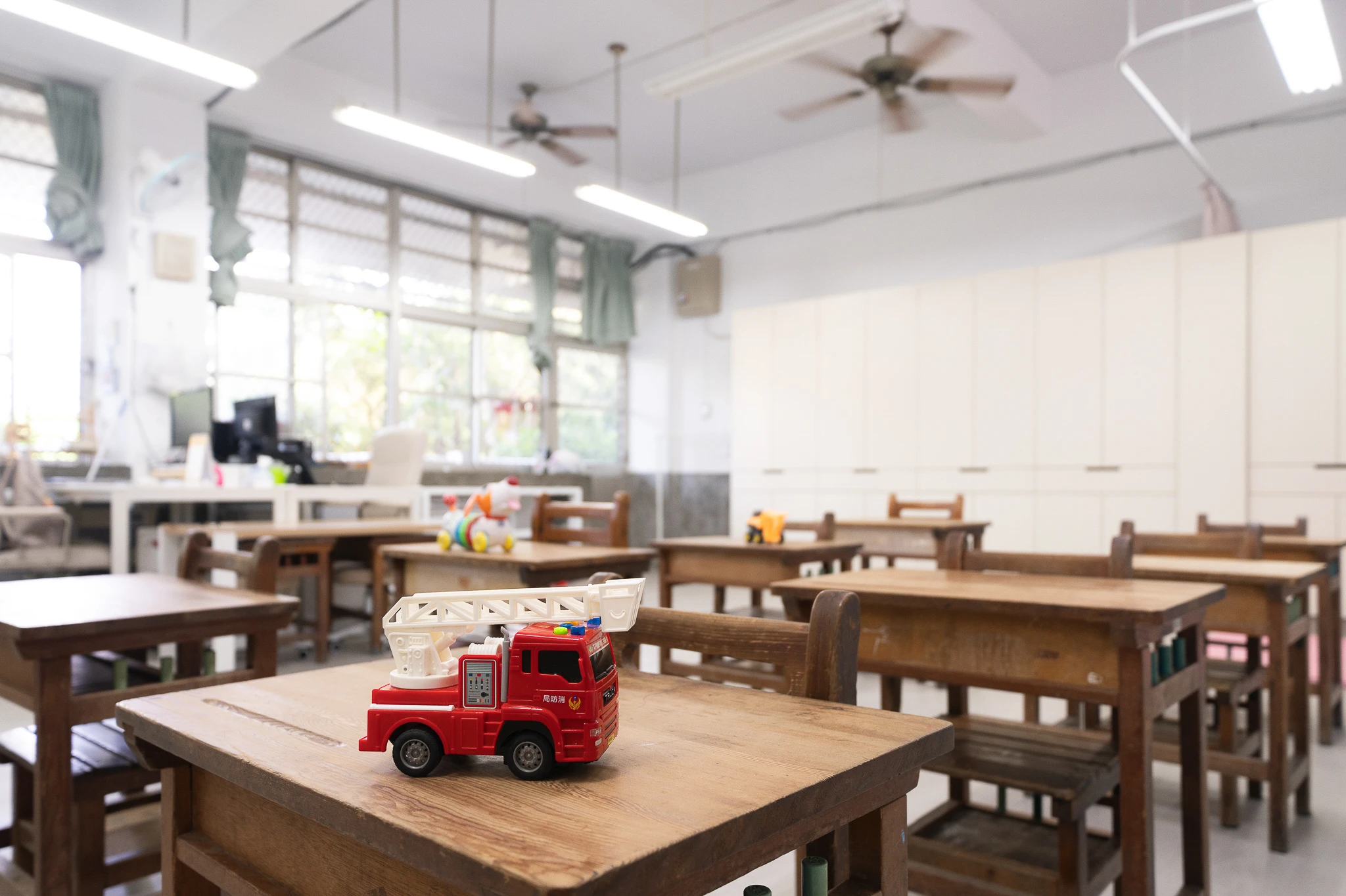 Classroom desk layout with a toy truck in the foreground