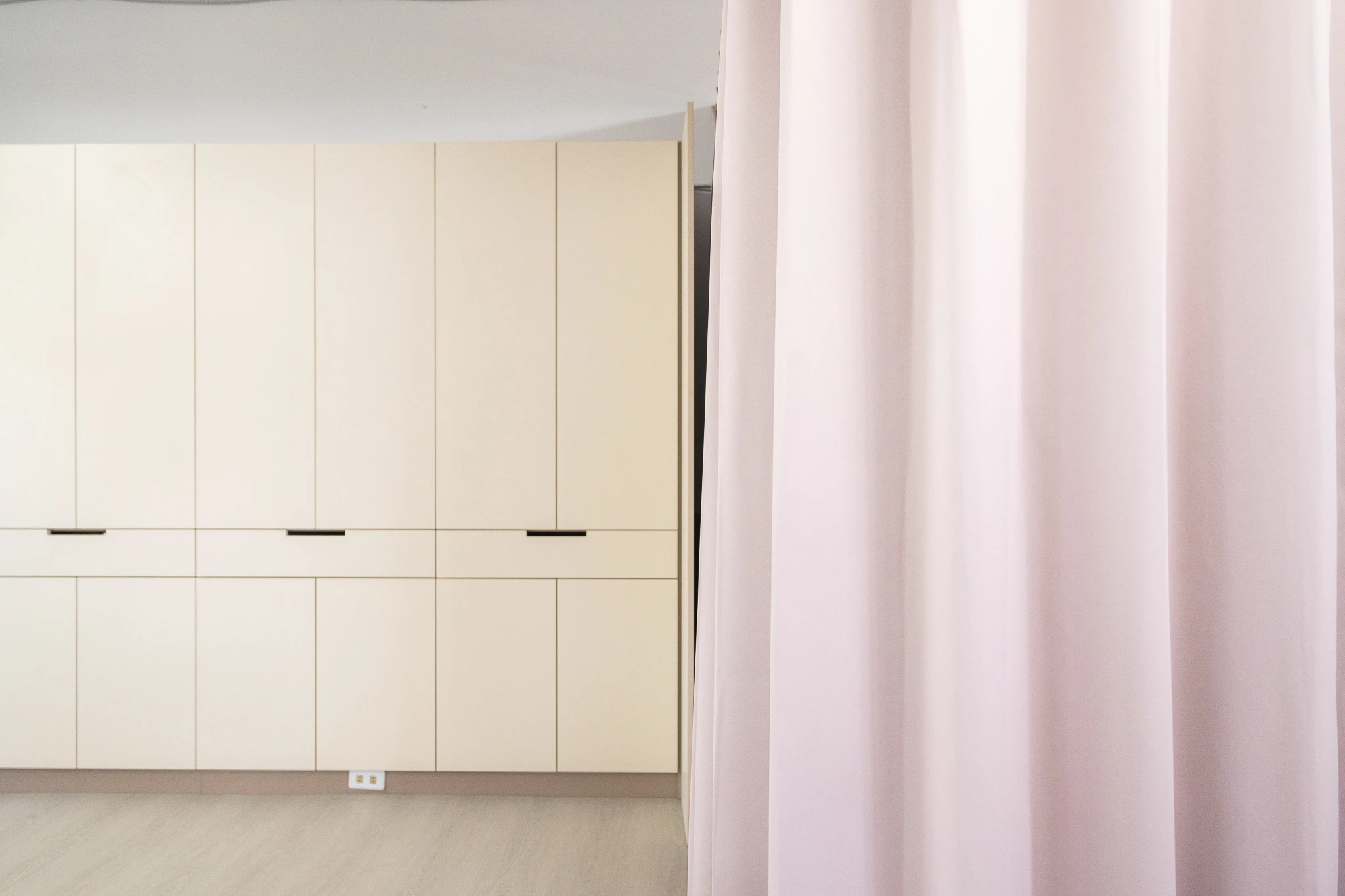 Close view of pale cabinet doors and curtain fabric