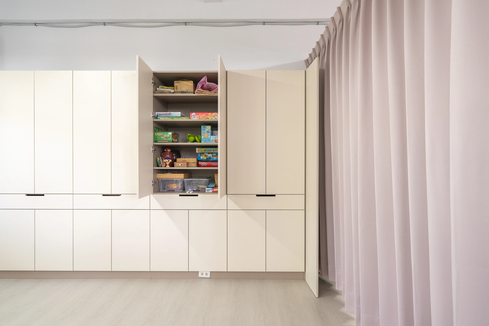 Open cabinet shelves holding learning materials