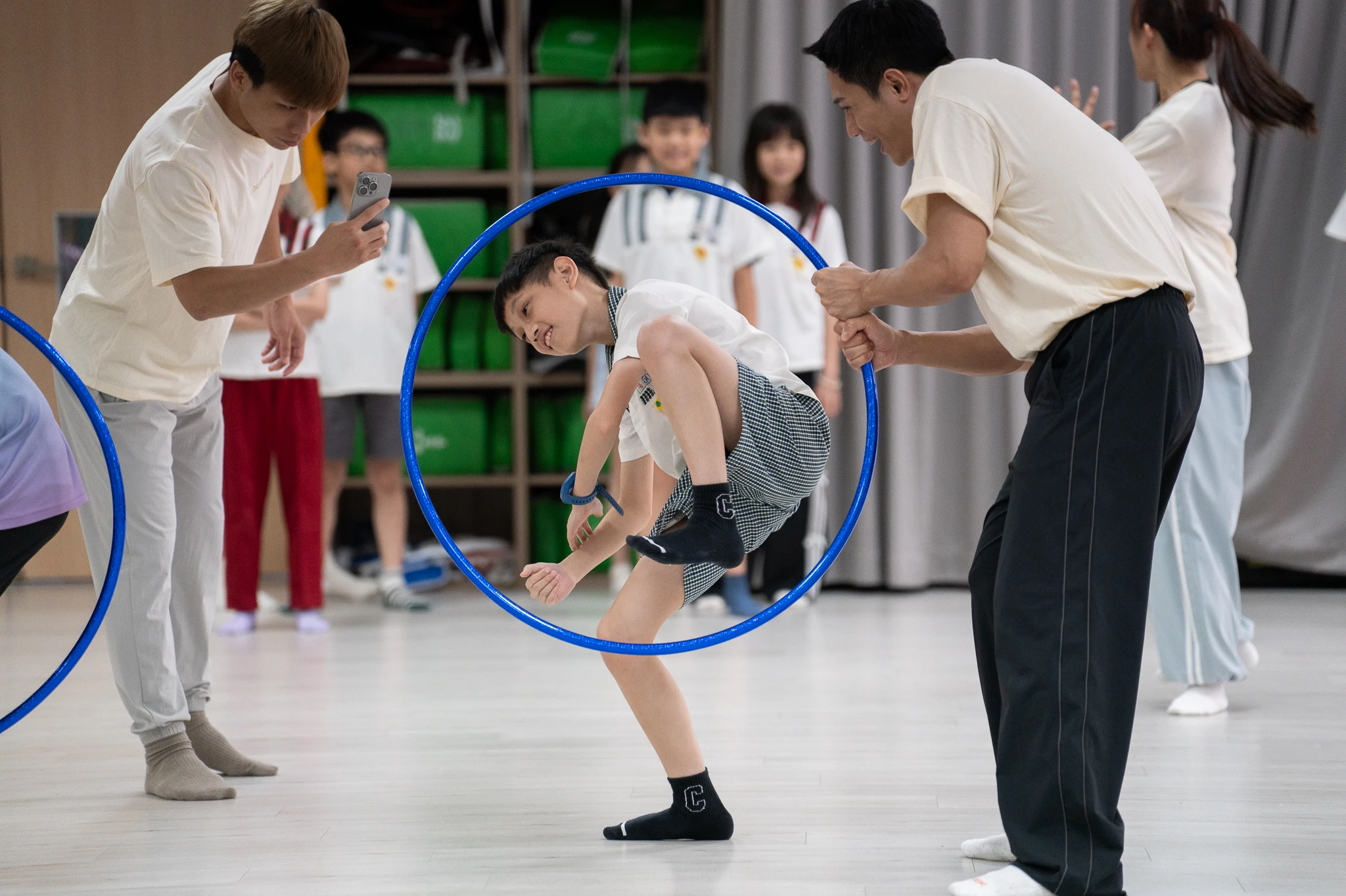 Student stepping through a hoop held by workshop facilitators.