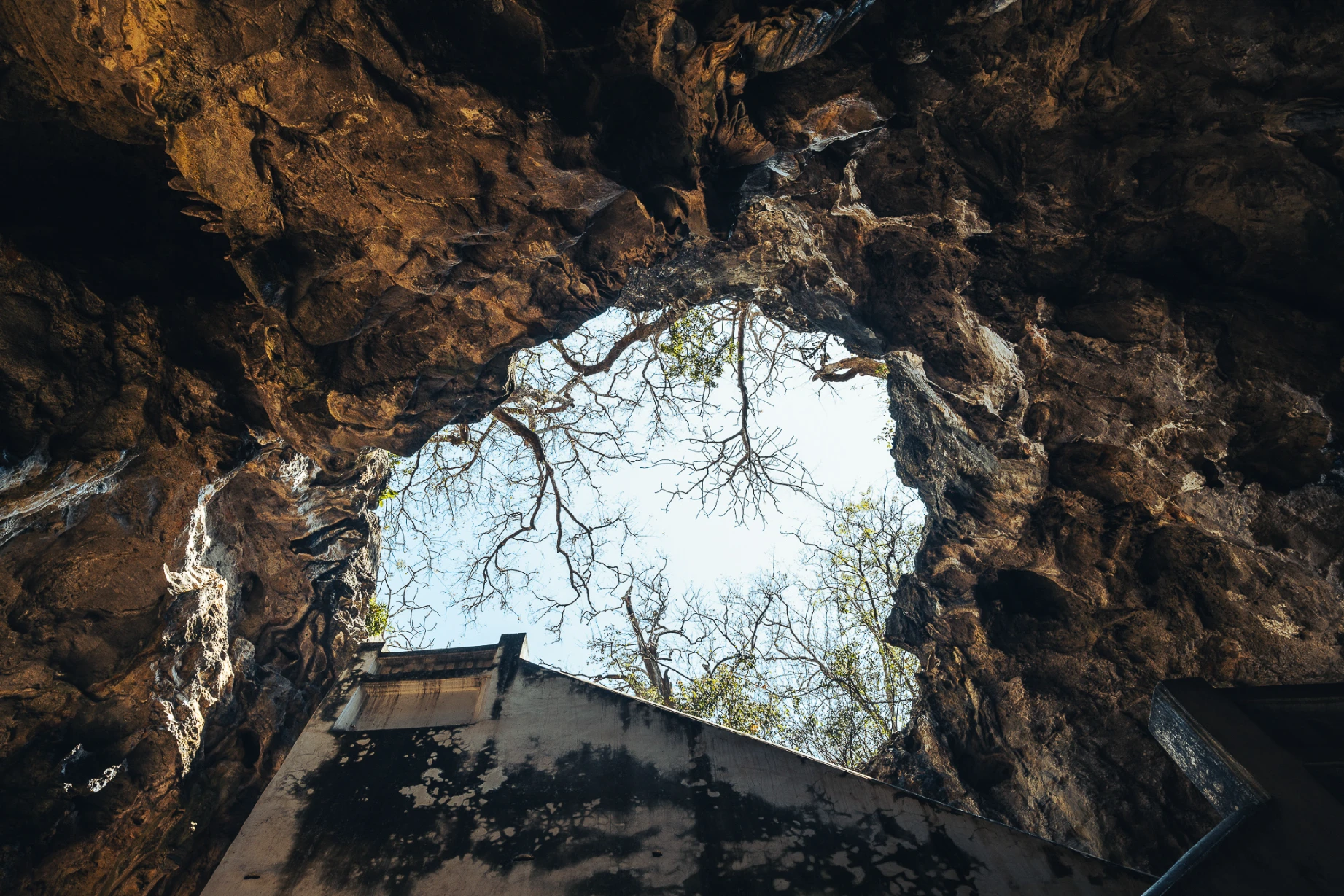 Natural light entering the sacred cave interior of Tham Khao Luang in Thailand.