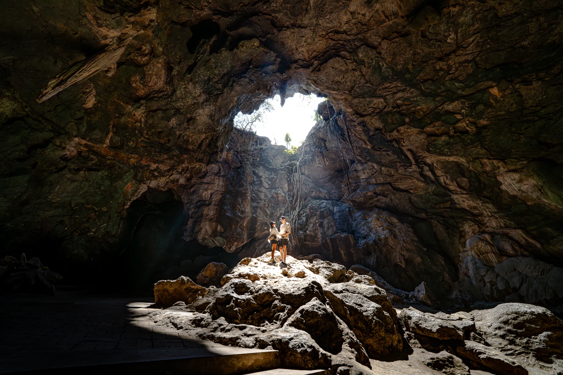 Natural light entering the sacred cave interior of Tham Khao Luang in Thailand.