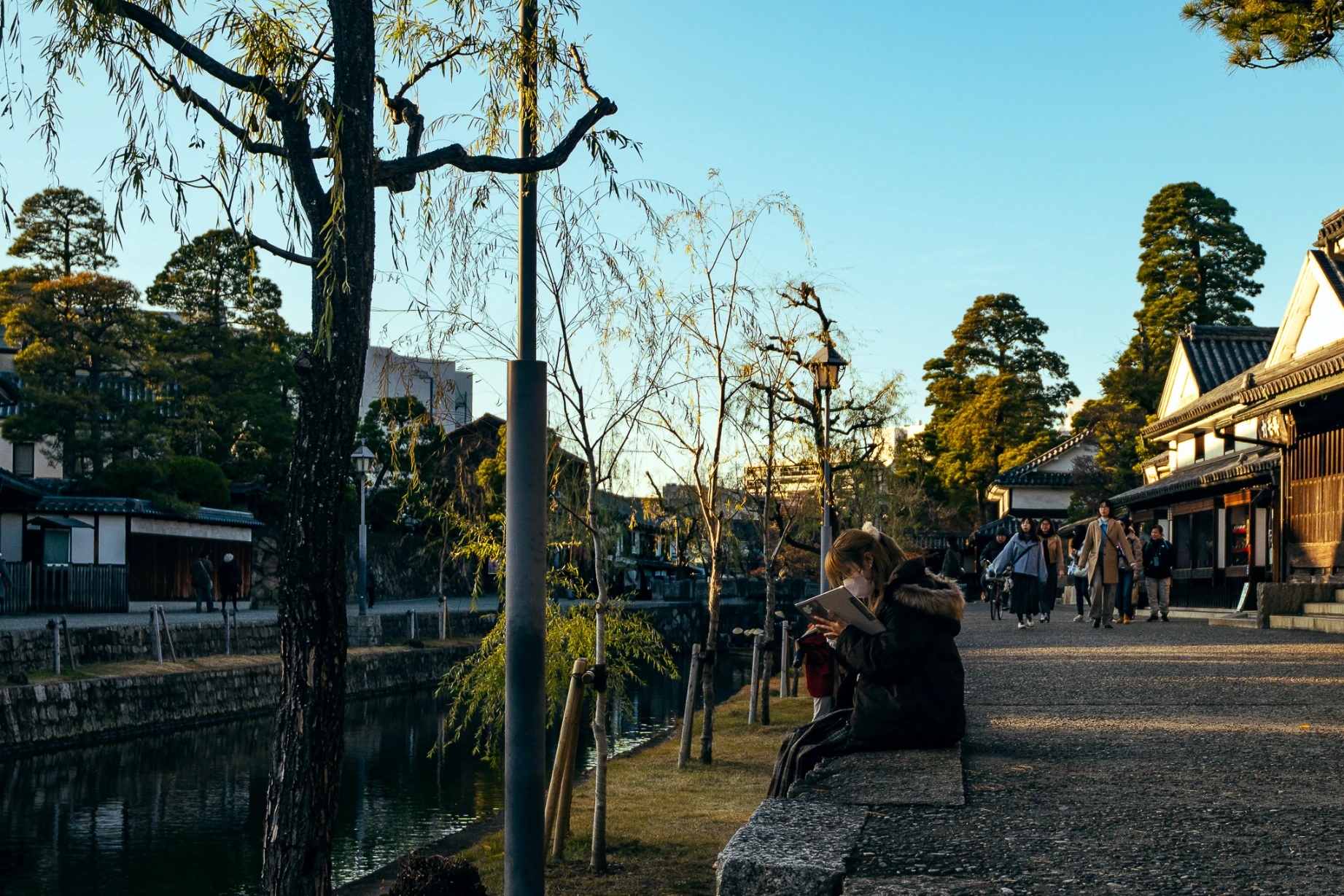 Canal and white-walled historic buildings in Kurashiki Bikan Historical Quarter.