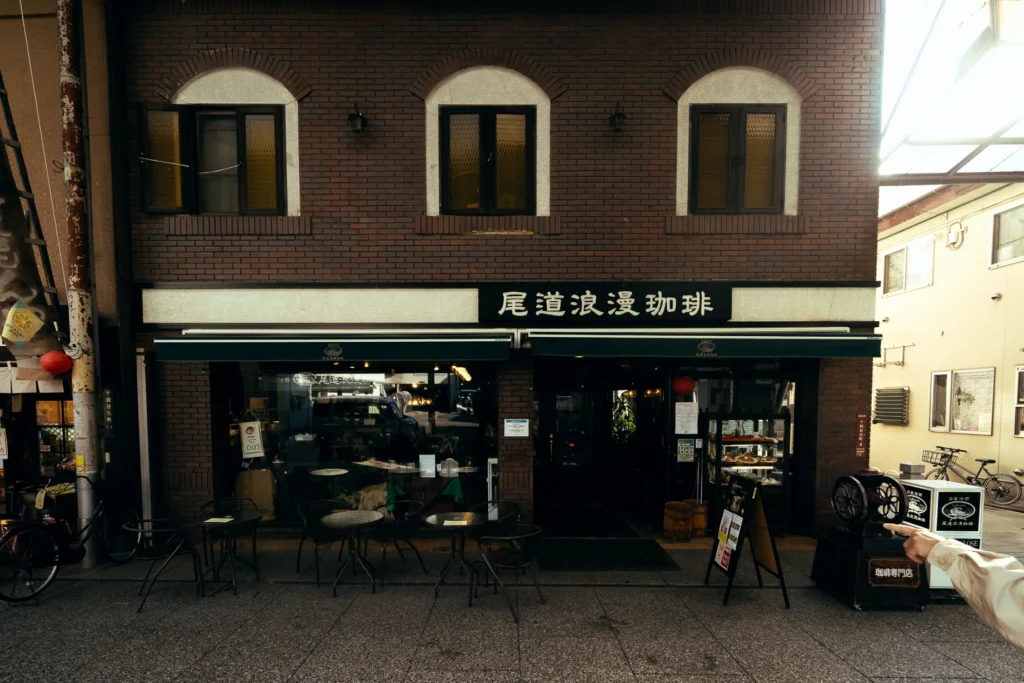 A traditional coffee shop beneath a dark brick facade.