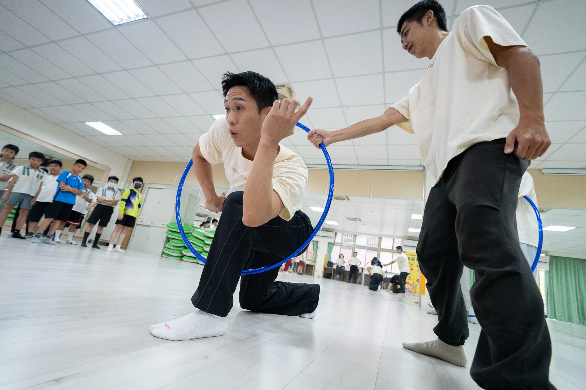 Two facilitators demonstrating how to move through a hoop.