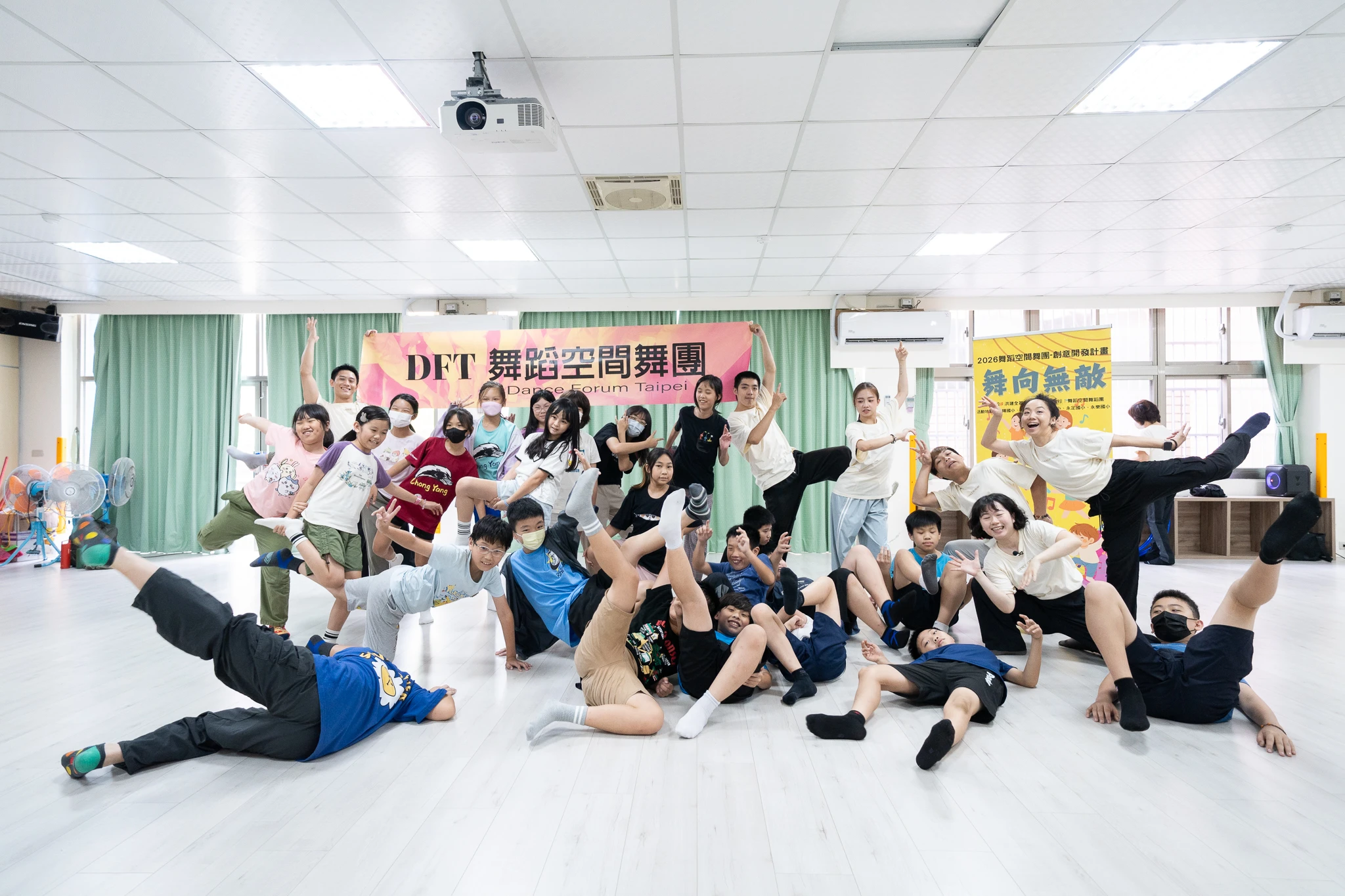 Workshop participants posing playfully together in a dance studio.