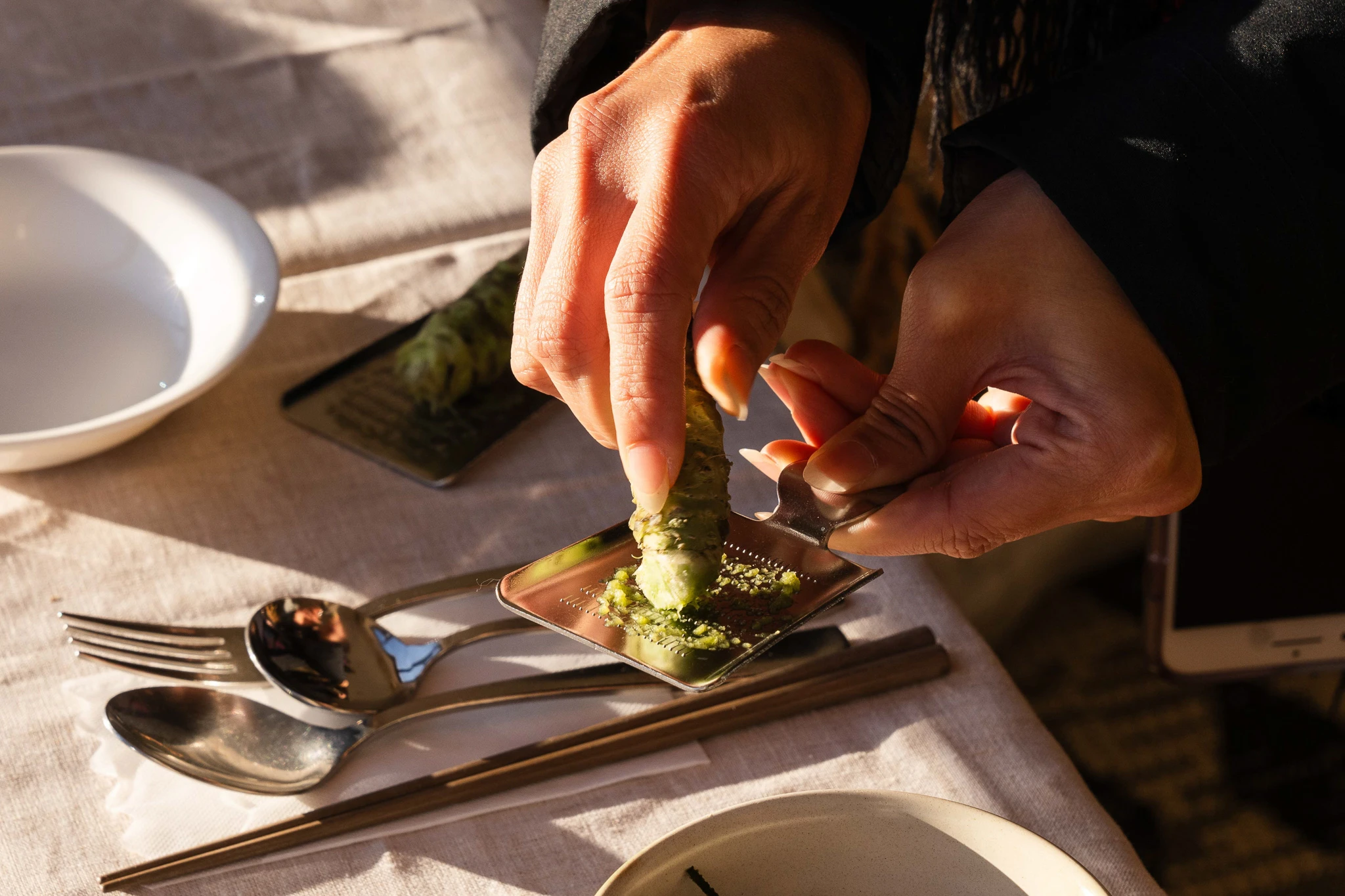 Hands preparing a bite of food at the table