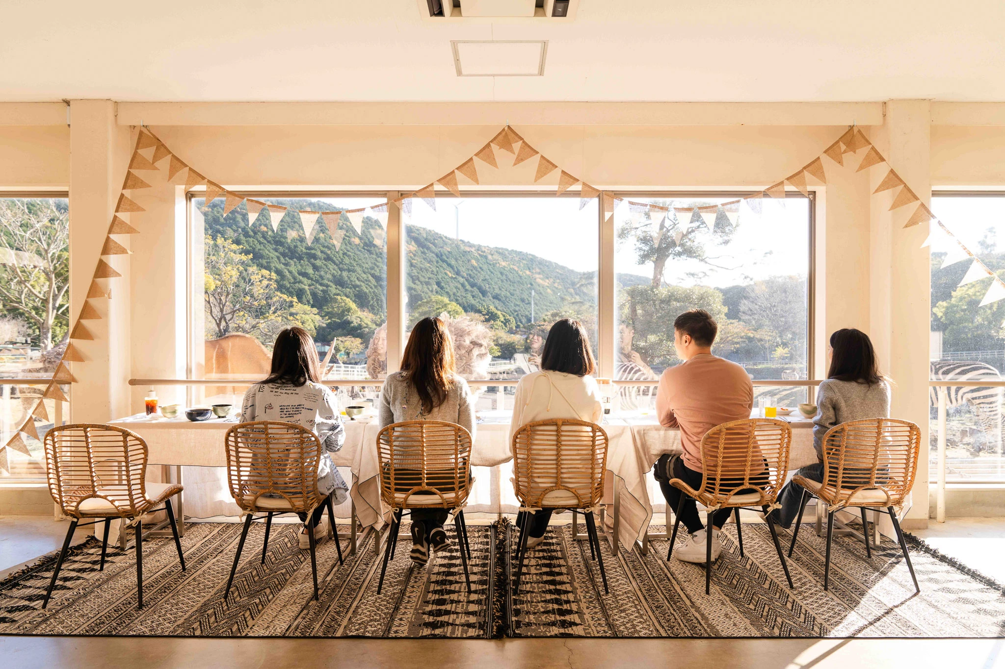 Travellers eating beside broad sunlit windows
