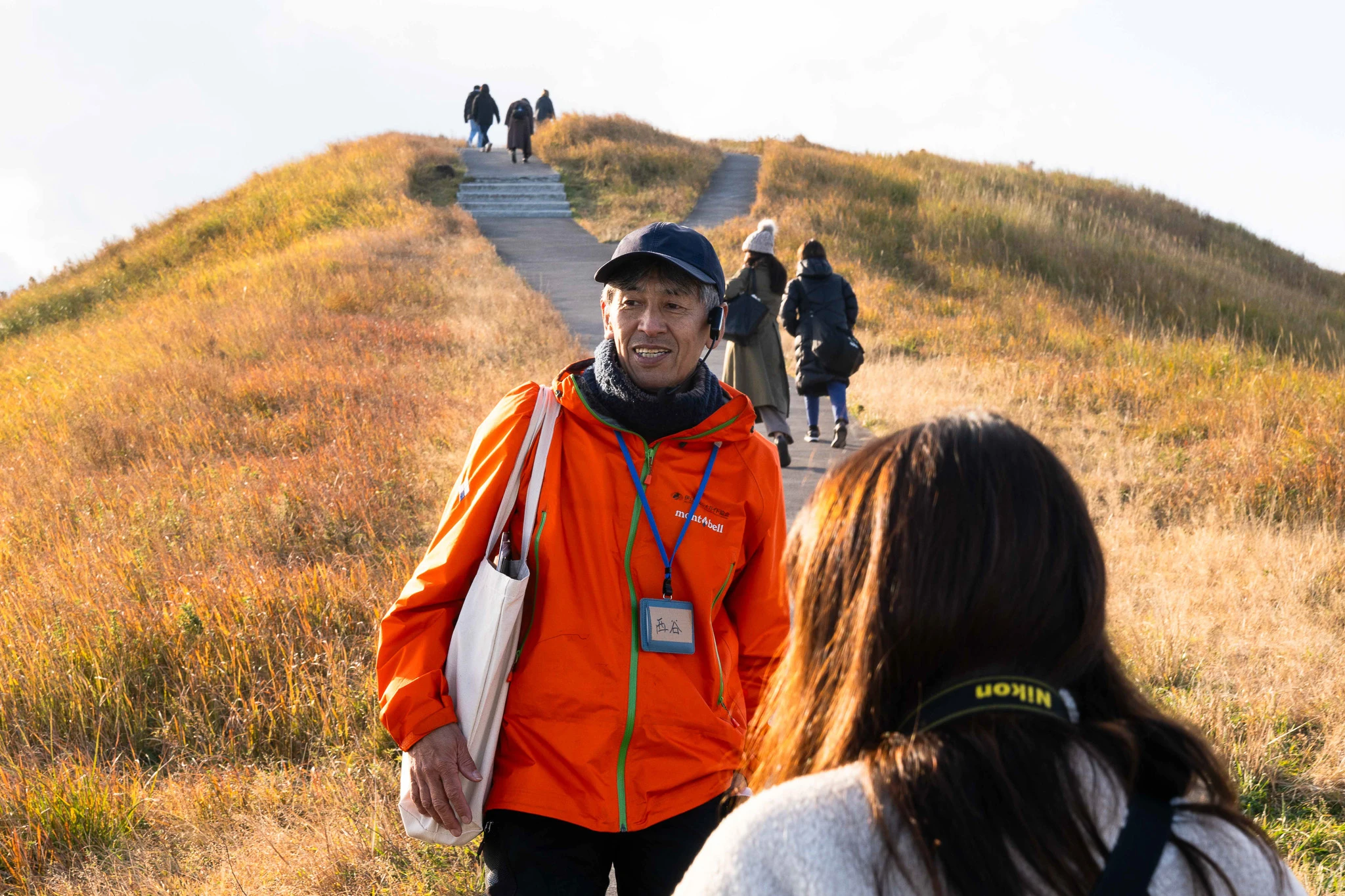 Guide speaking with visitors on a hillside path