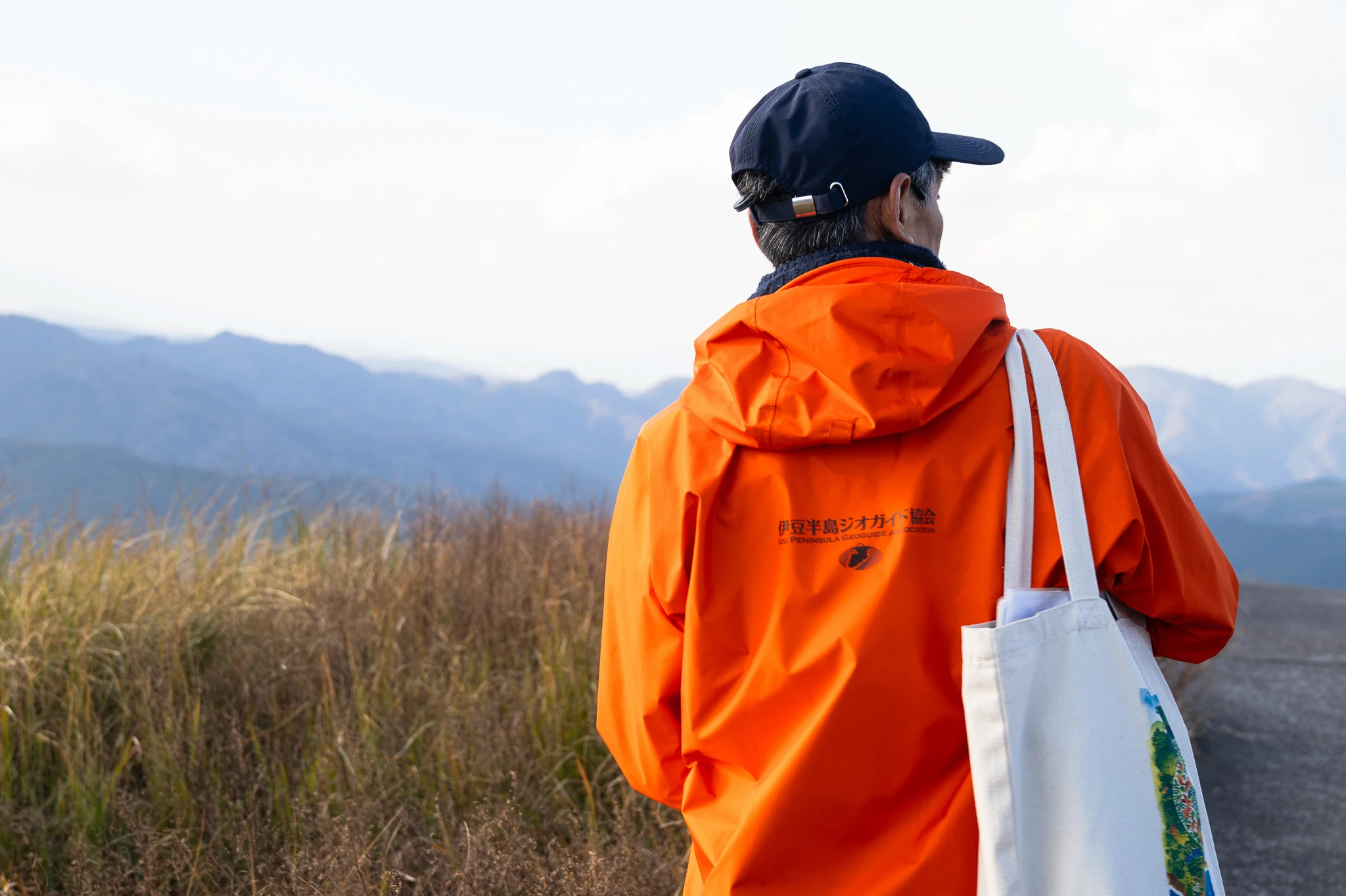 Guide in an orange jacket overlooking the hills