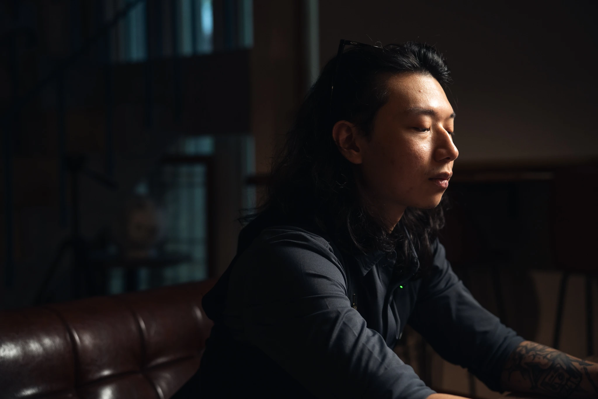 Side-lit portrait of a seated person at Moonwell
