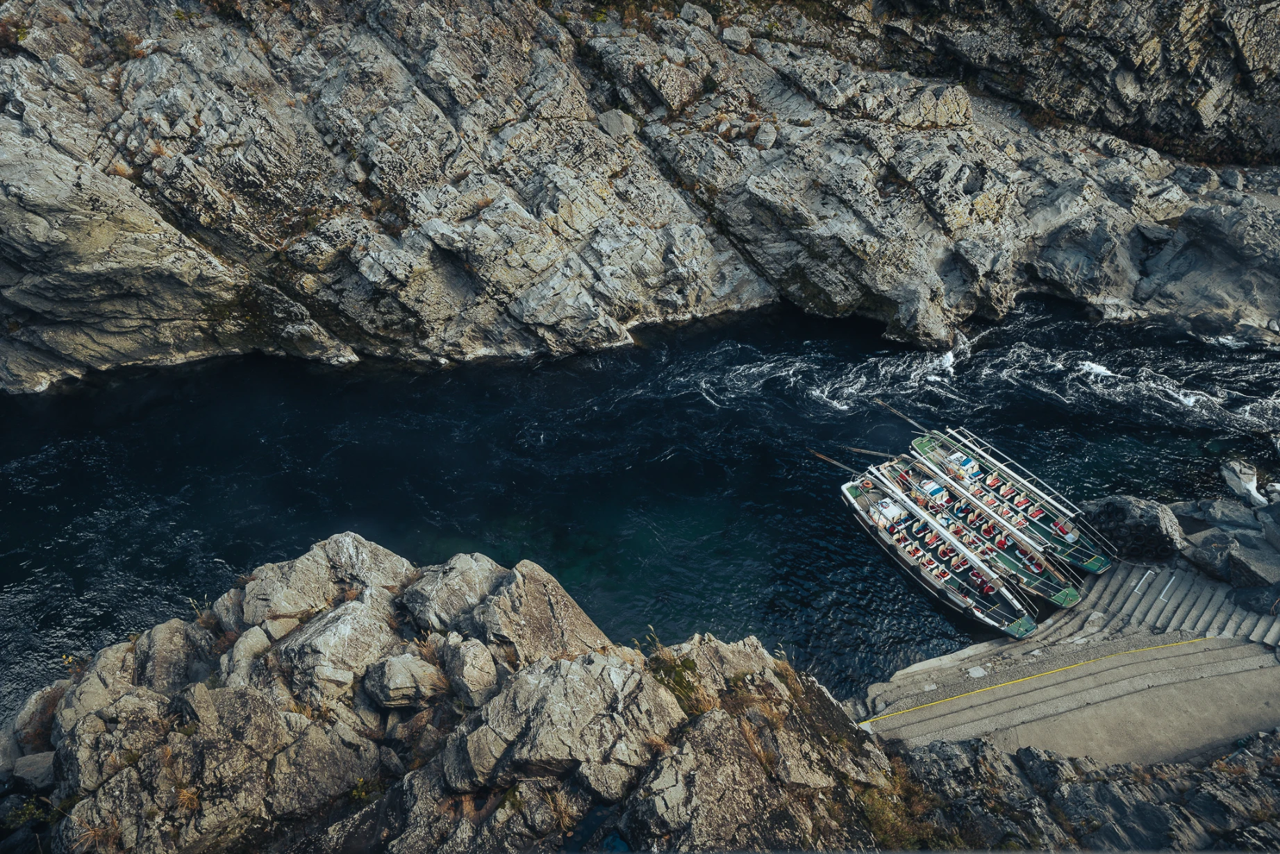 Boat journey through the steep rock walls and blue water of Oboke Gorge.