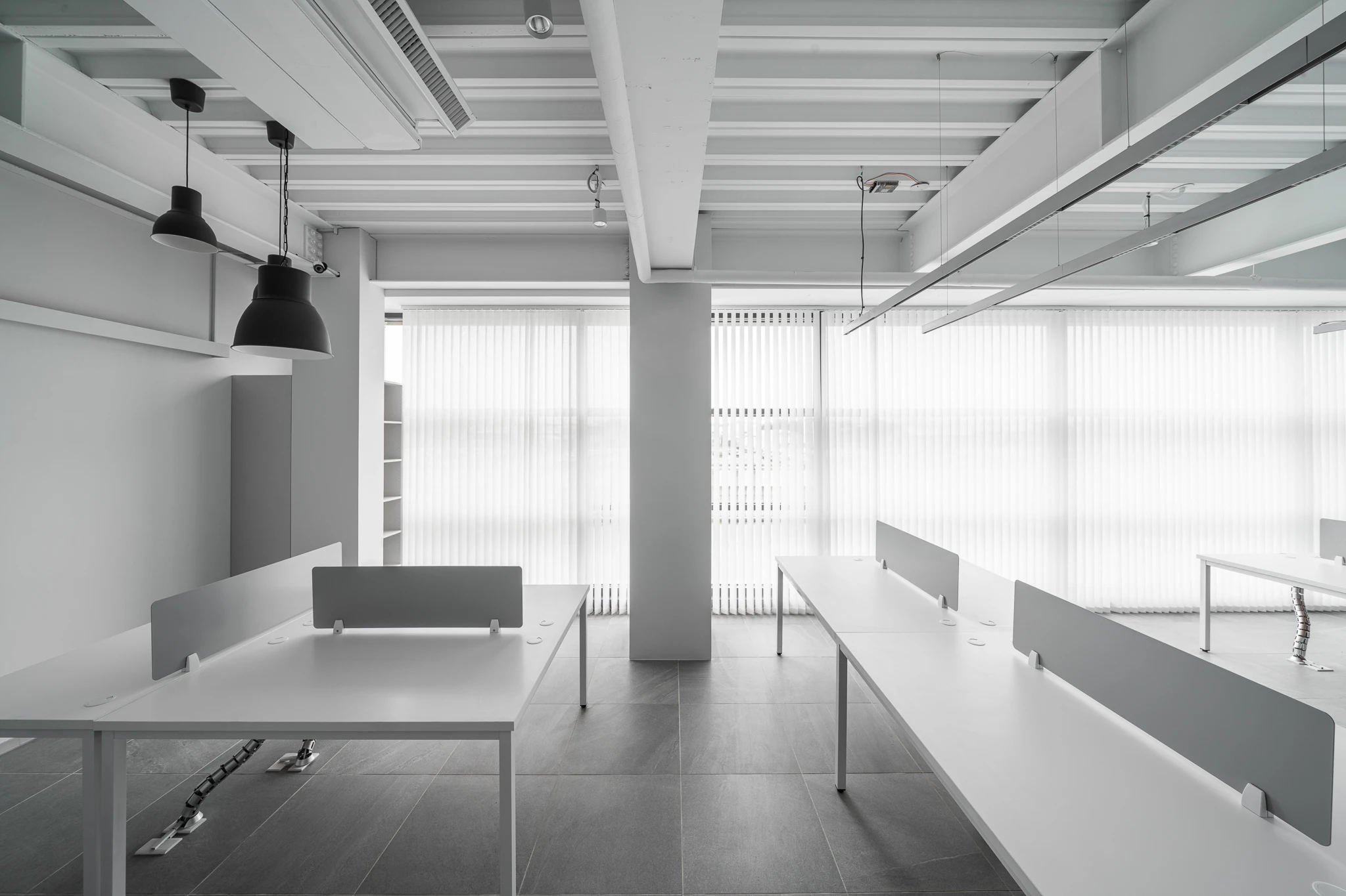 Daylight falling across partitioned office desks