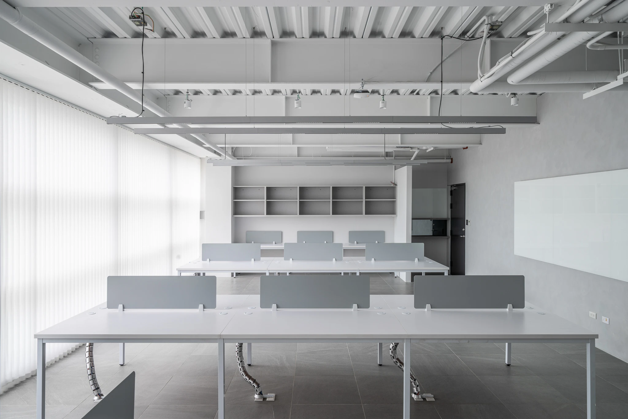 Wide view of the open office and ceiling pipework