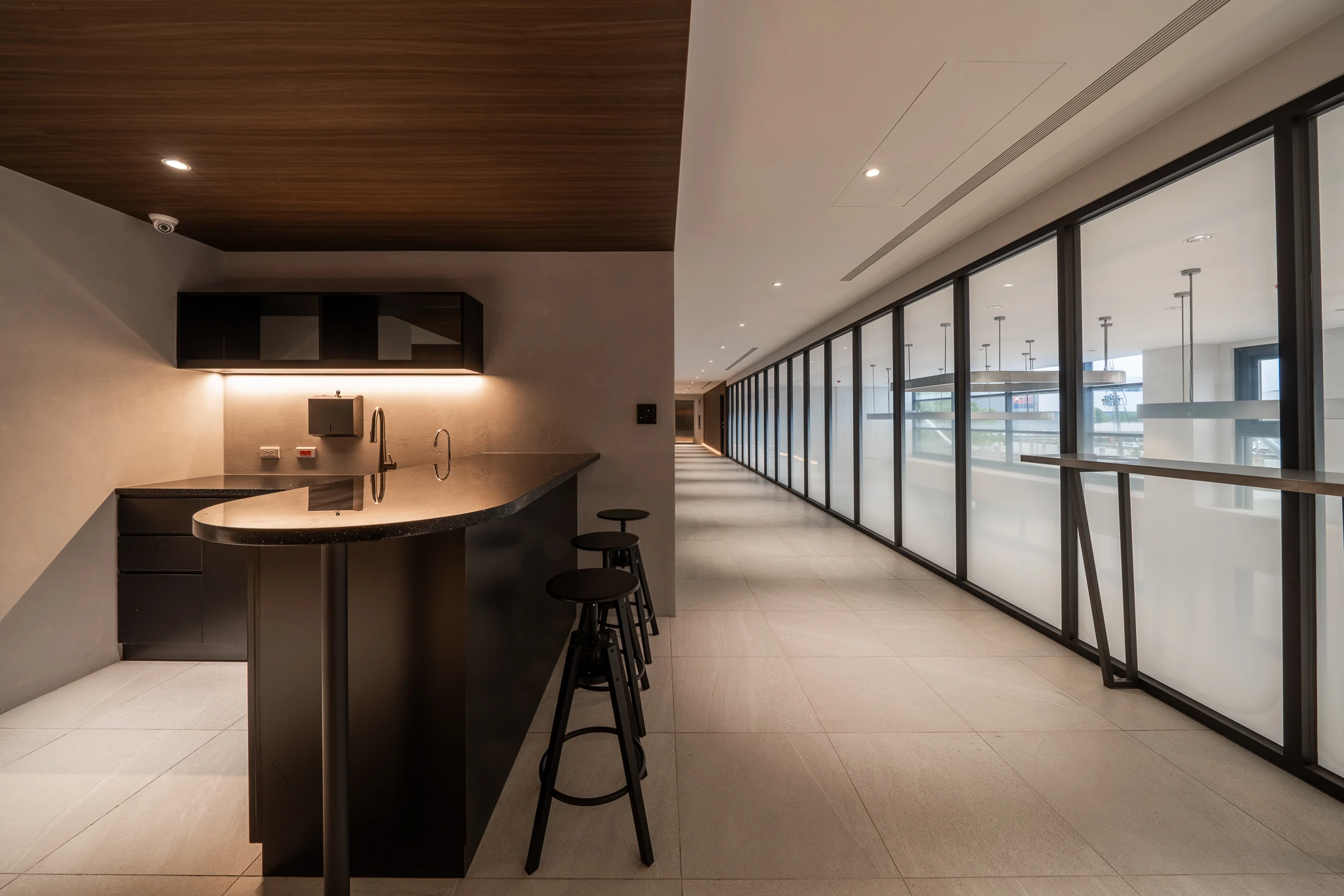 Bar seating beside a glazed corridor