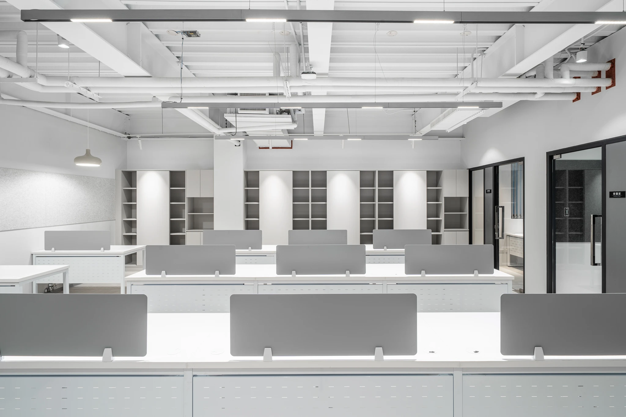 Office workstations facing a wall of storage shelves