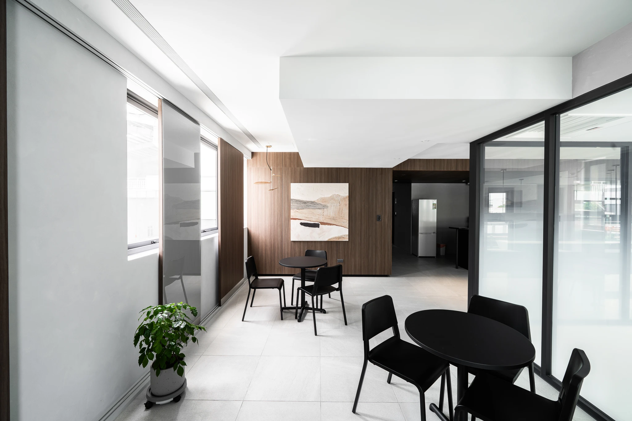 Small seating tables beside glass office partitions