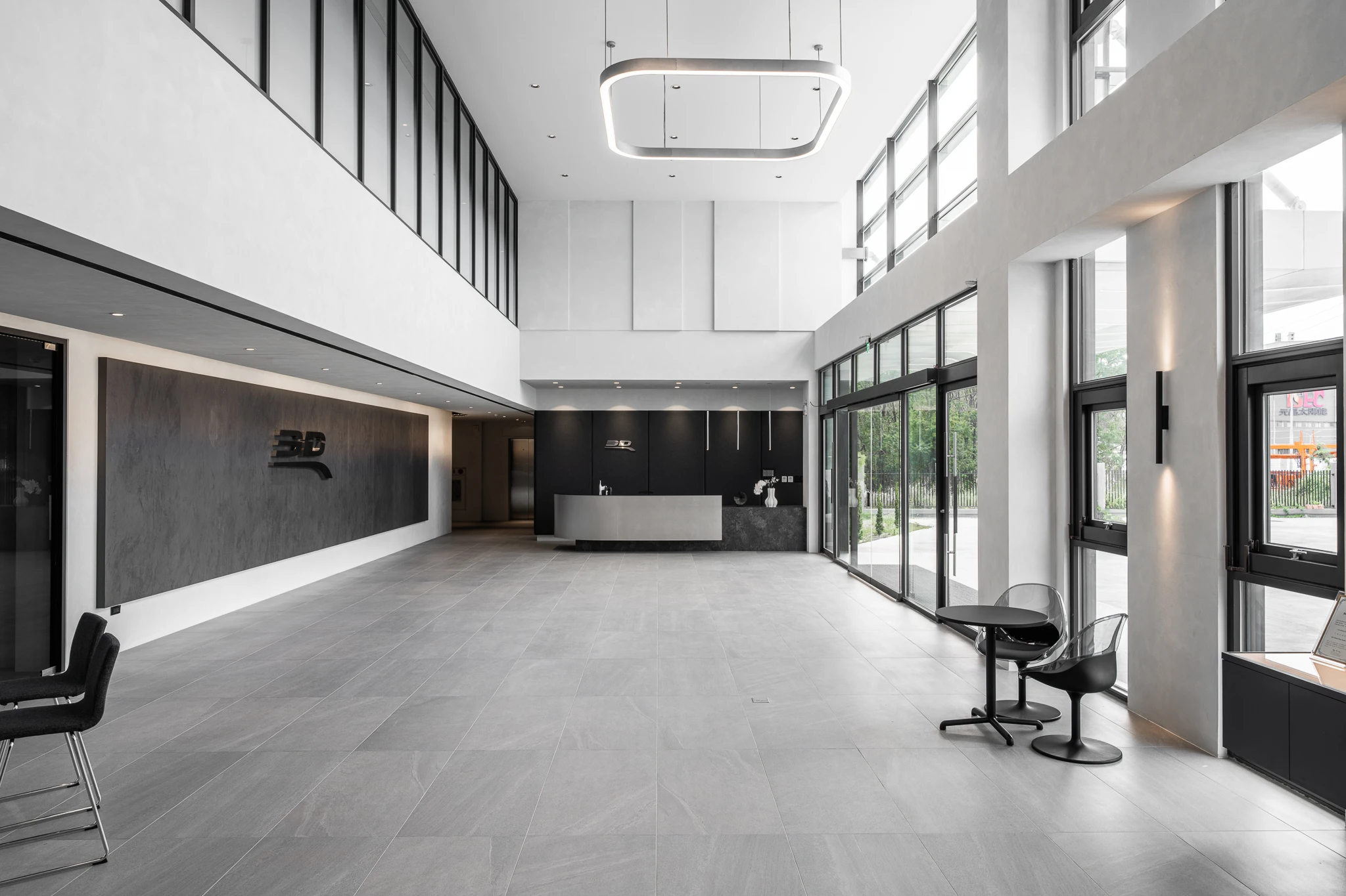 Double-height factory reception with a long counter and tall windows