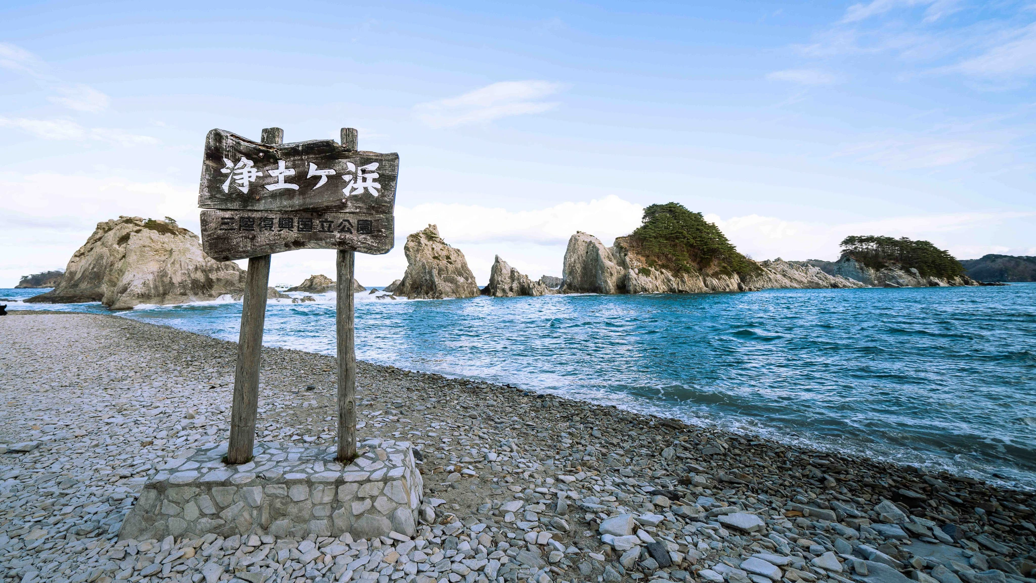 Jodogahama sign beside white coastal rocks and blue water