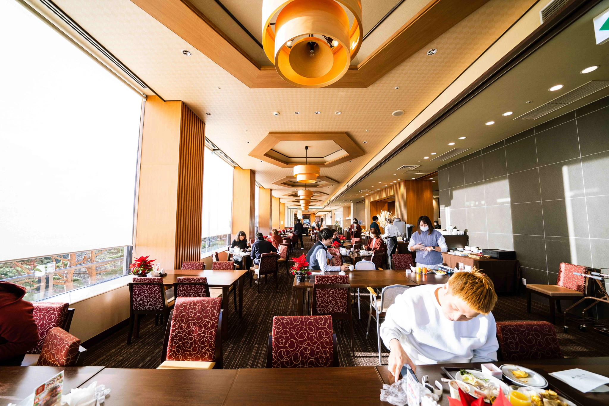 Hotel dining room with guests beside the windows