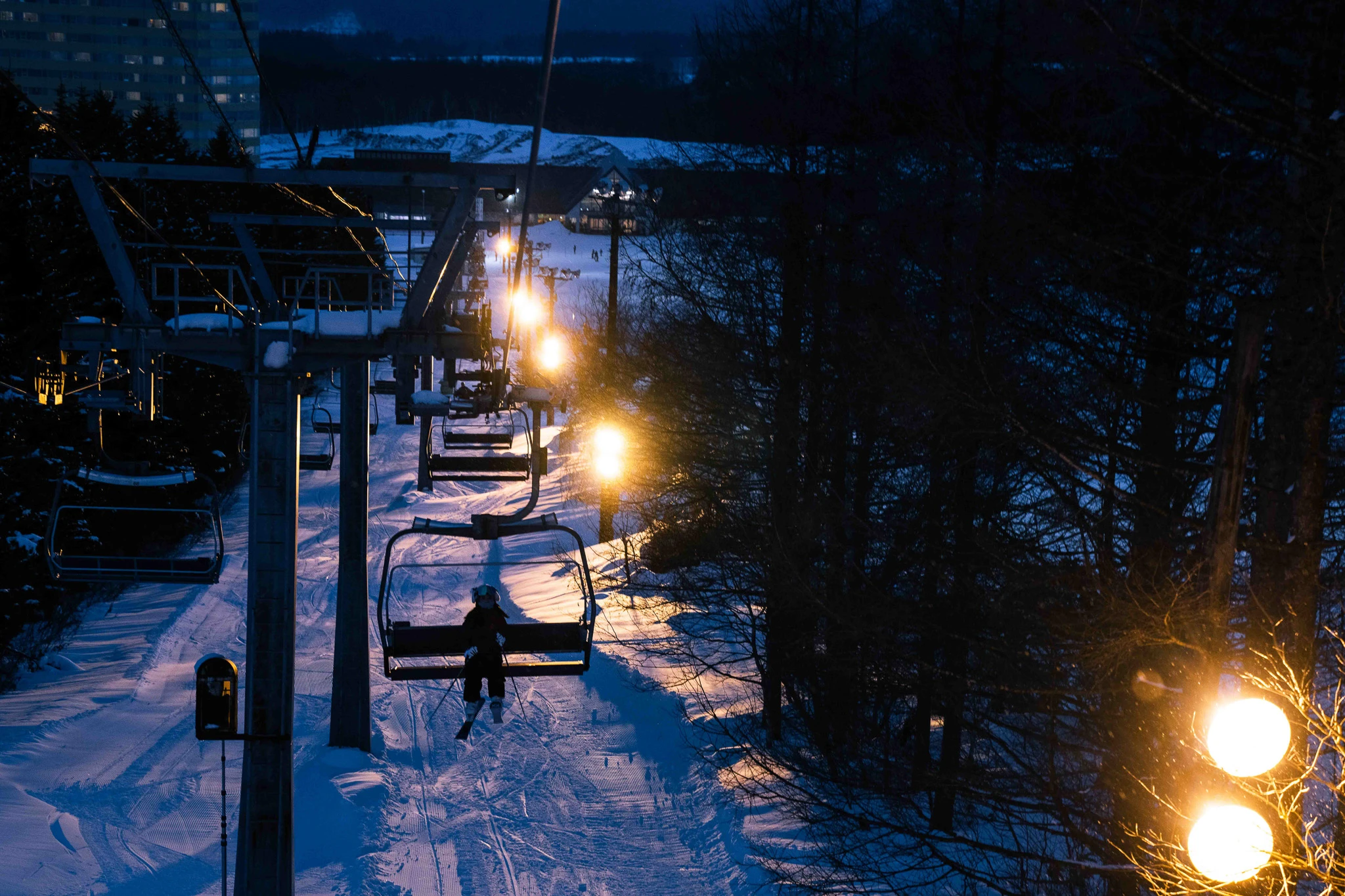 Warm lift lights against a dark winter landscape