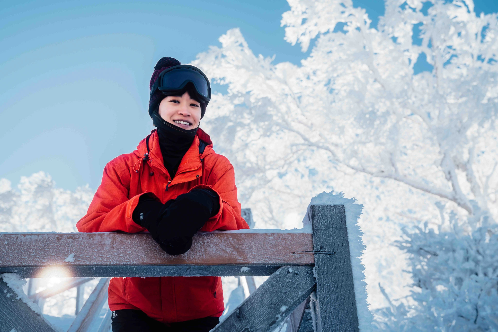 Winter portrait in a red jacket beside white trees