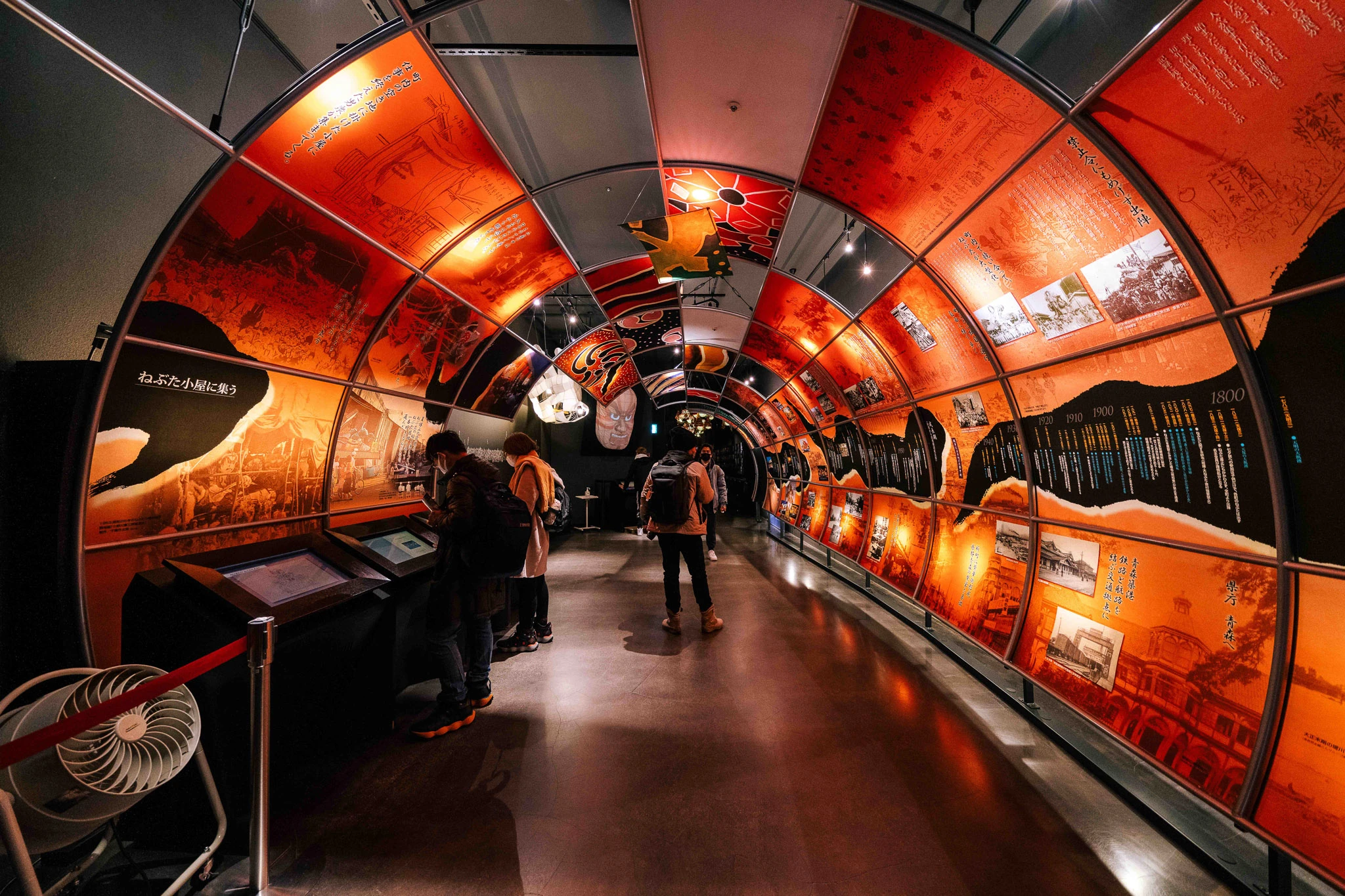 Visitors walking through a curved exhibition passage