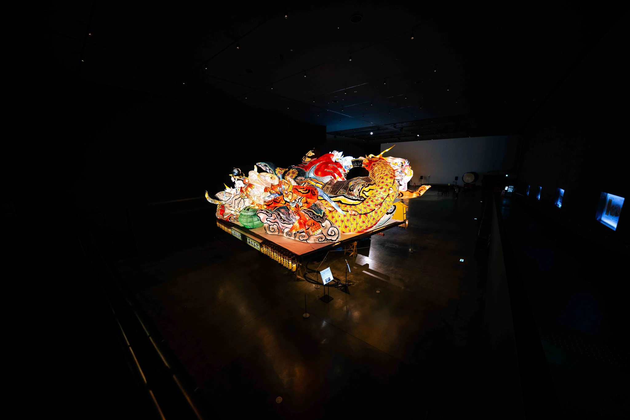 Wide dark exhibition hall with a glowing float