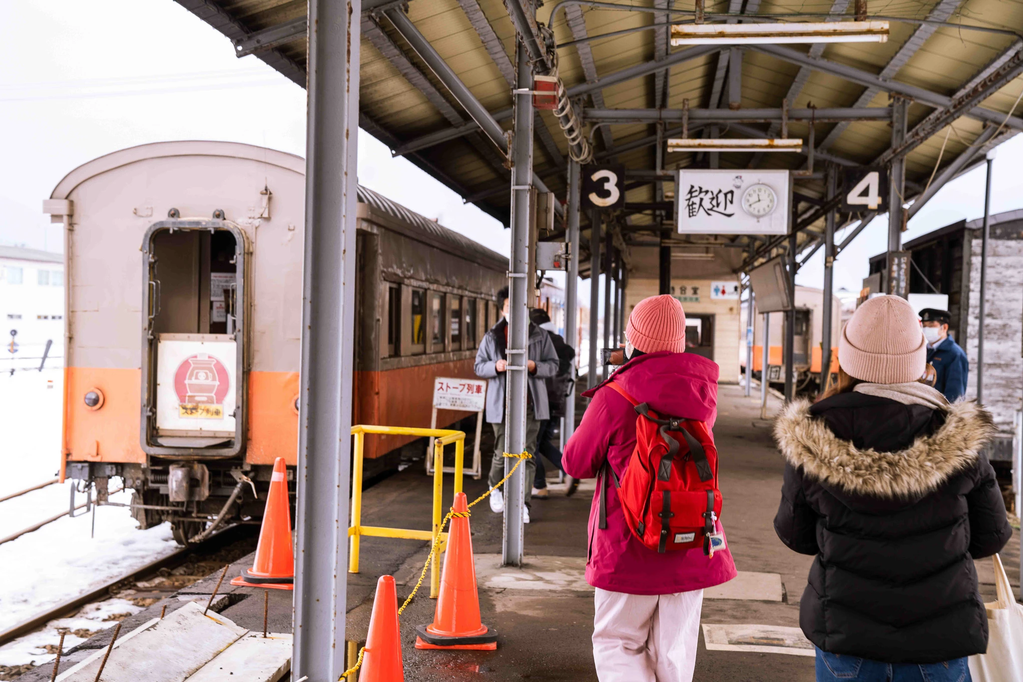 Travellers approaching the train along the platform