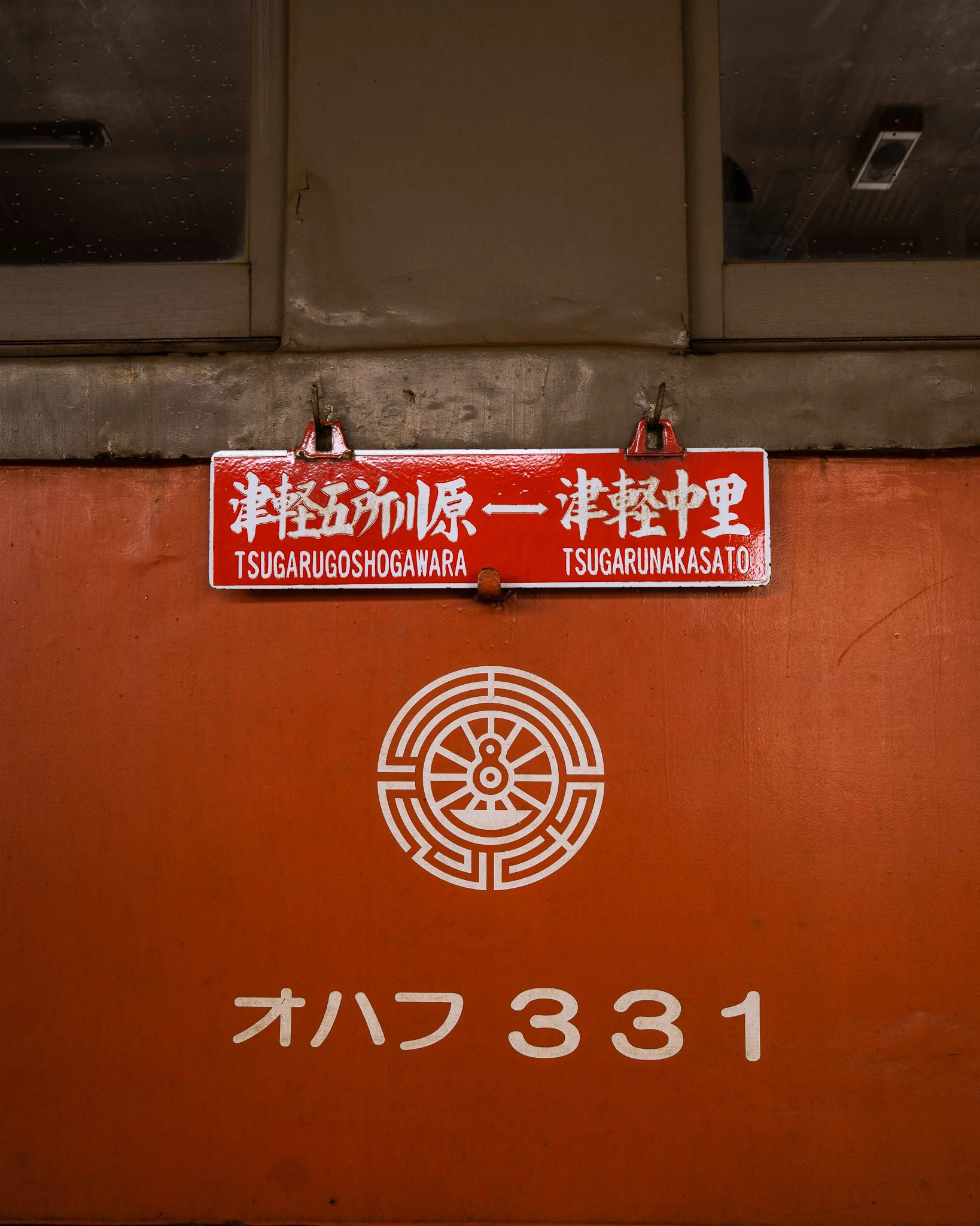 Orange carriage panel with Tsugaru railway signage