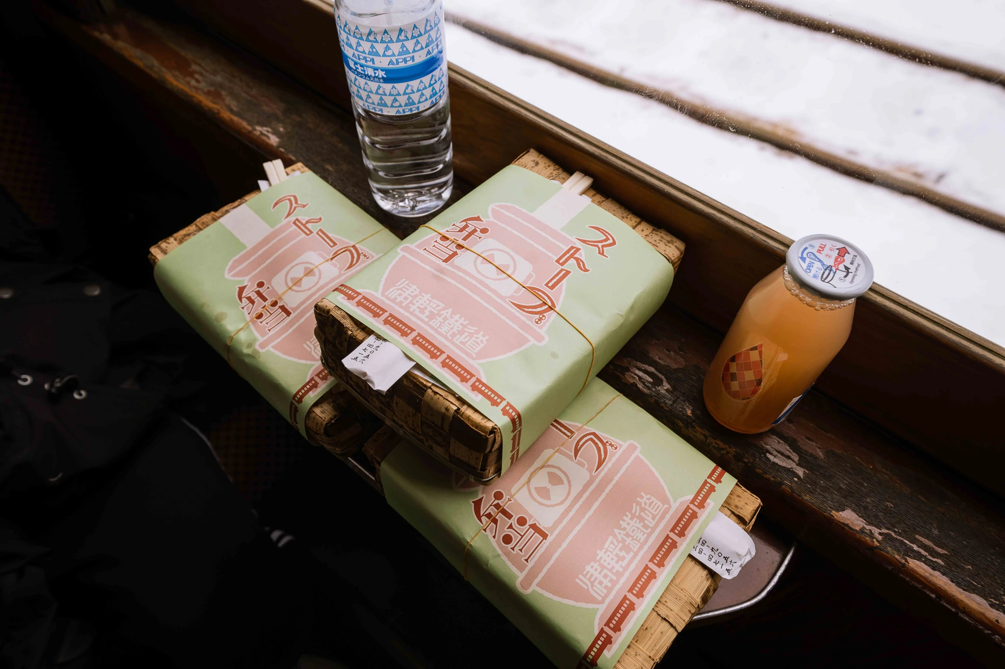 Wrapped lunches and drinks beside a train window