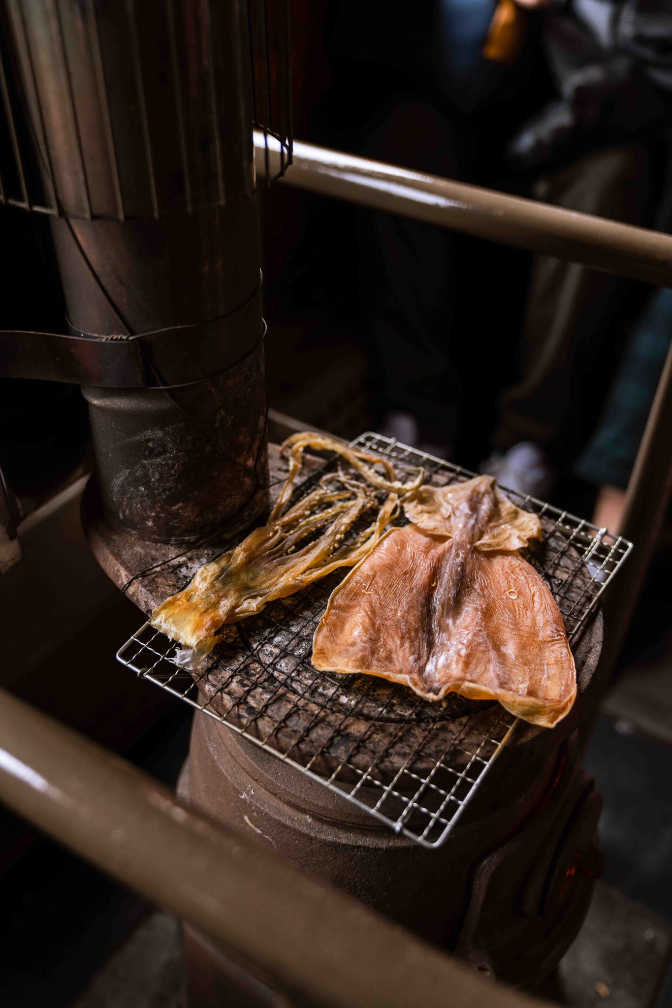 Food rests on a wire grill above the carriage stove, beside its dark metal pipe.