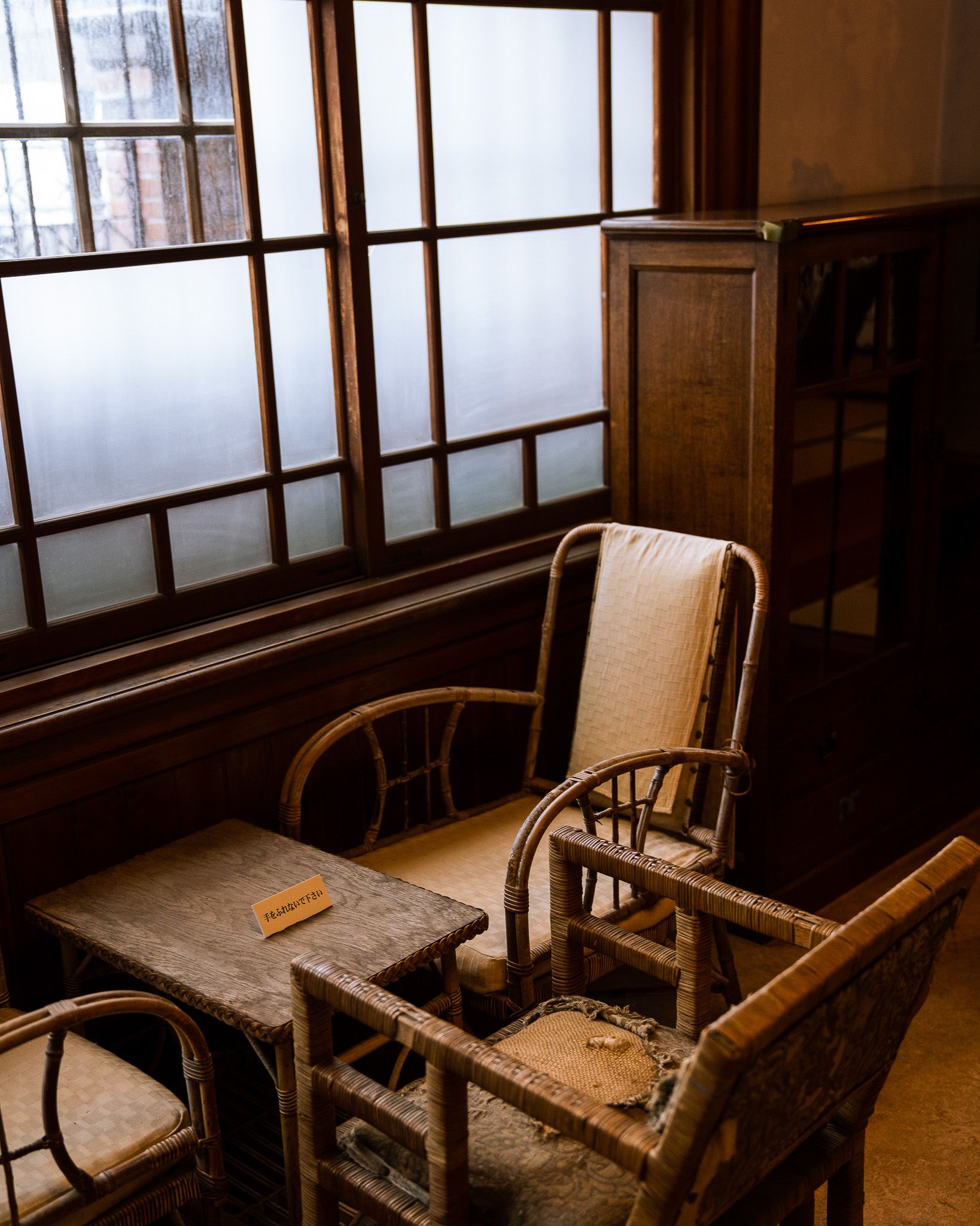 Wooden armchair beside a paper-screen window