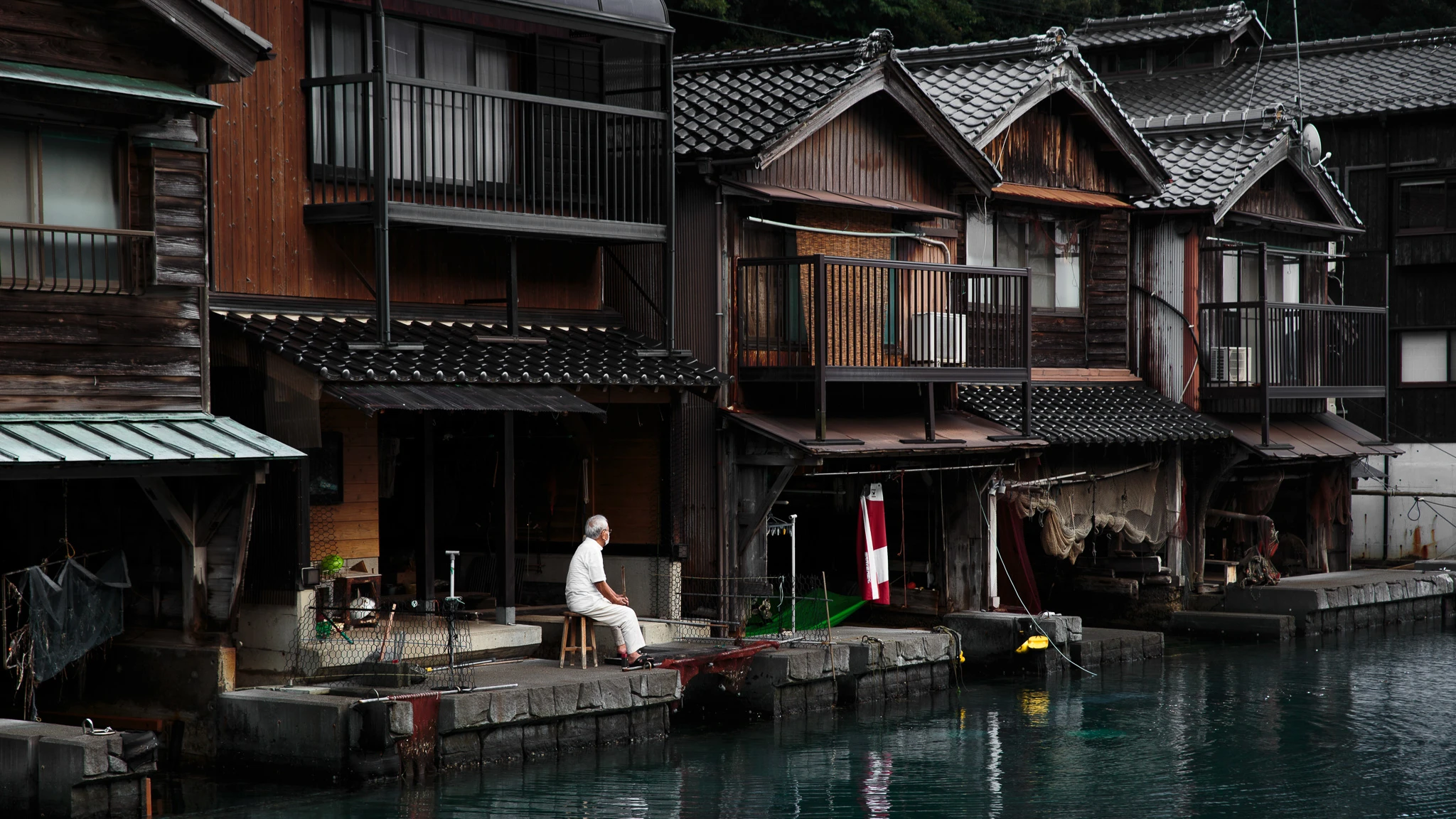 Waterfront seating beneath a timber boathouse facade