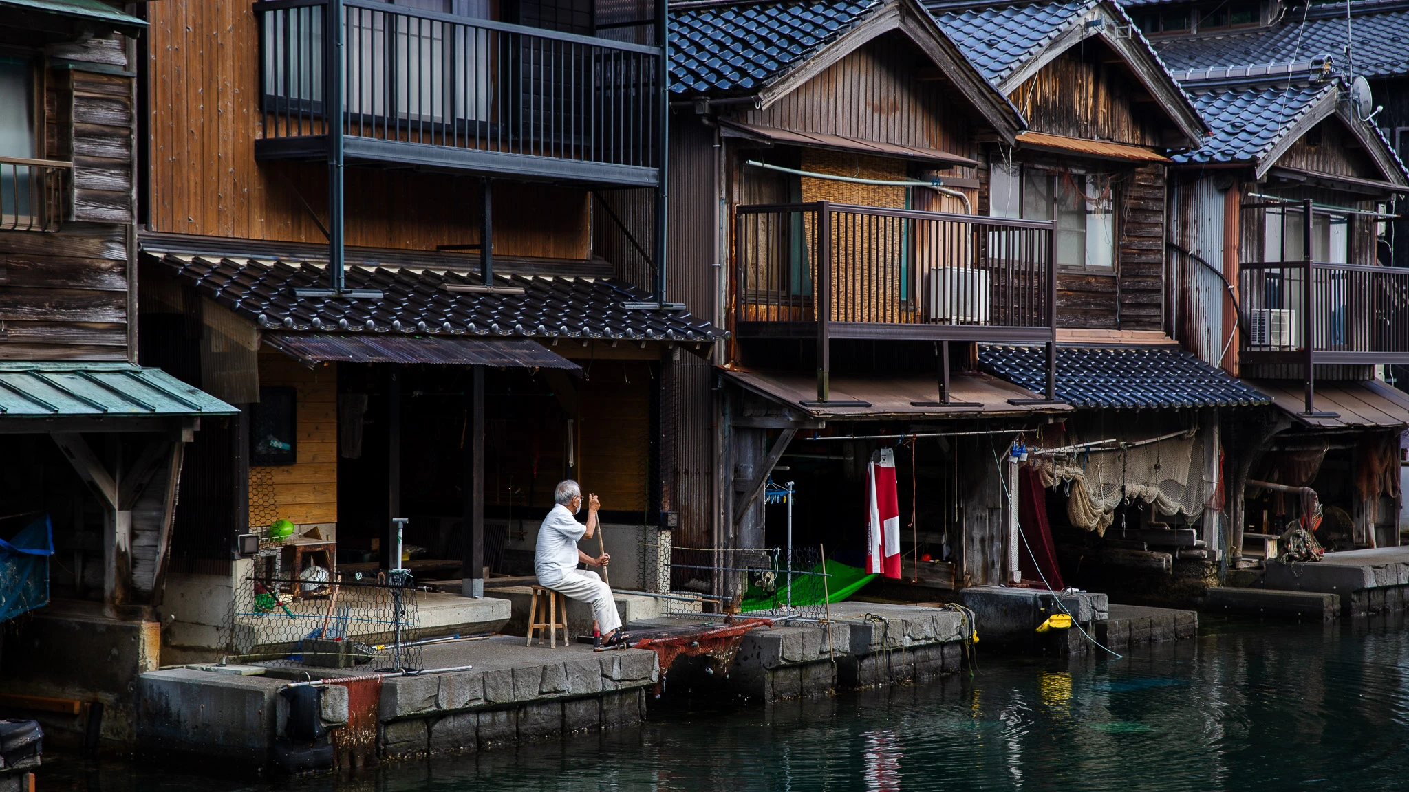 Timber boathouses at the water's edge in Ine