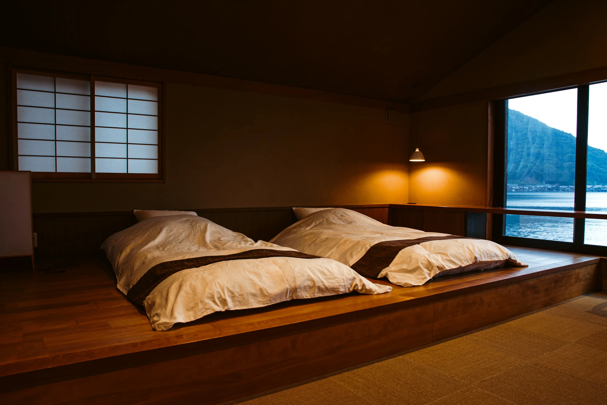 Futon beds on a raised platform beside a sea-facing window