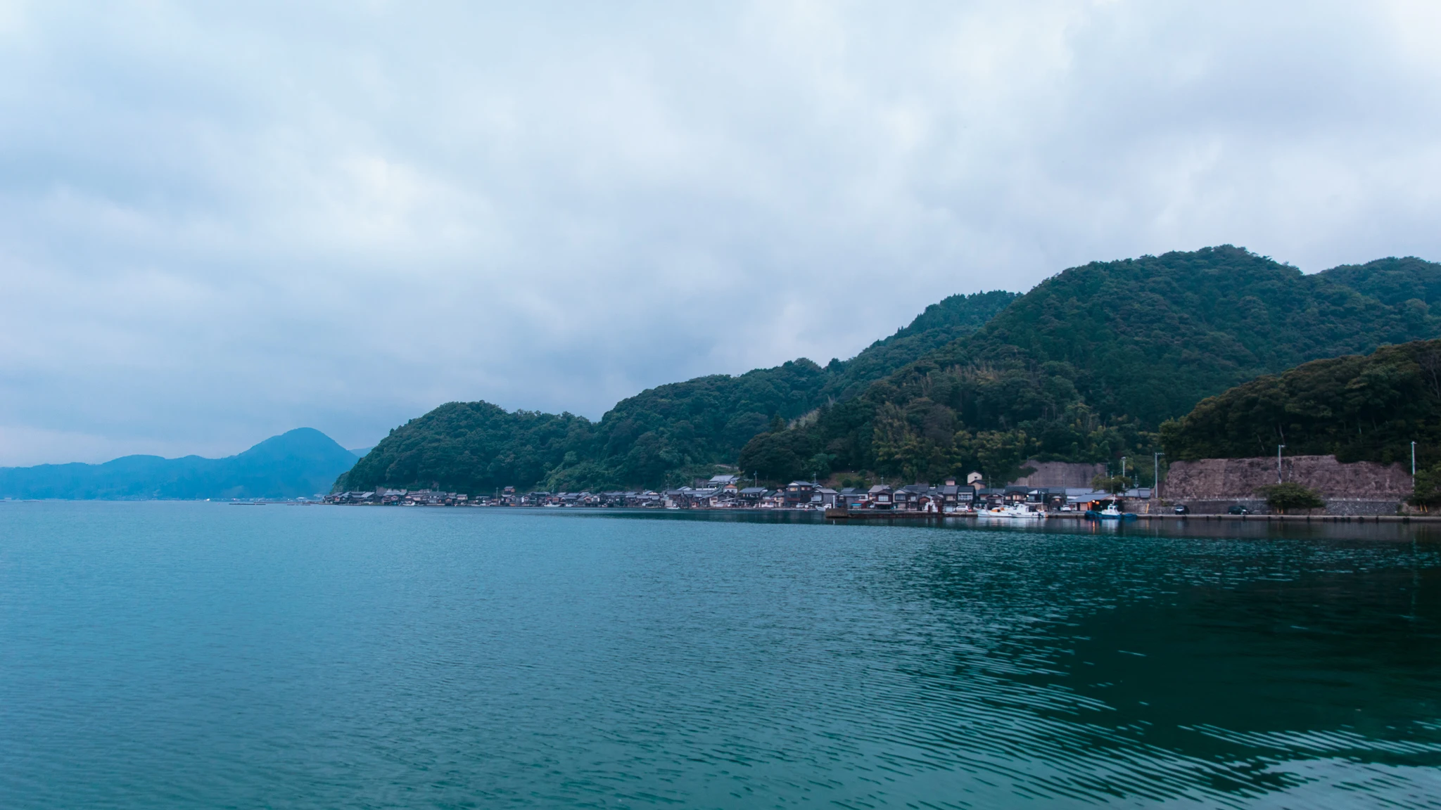 Blue-grey bay and mountains beneath cloud