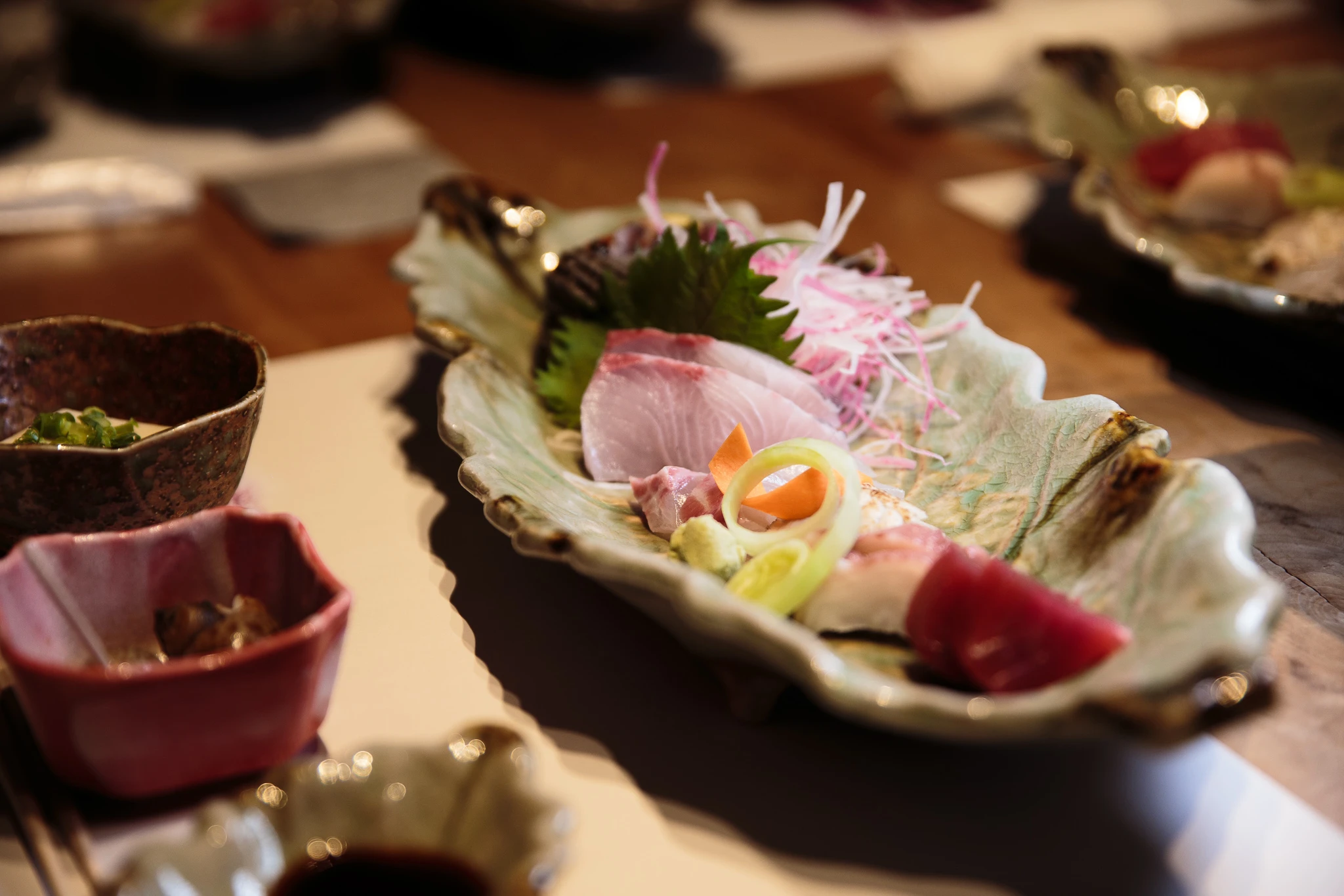 Sashimi arranged on a ceramic plate at dinner