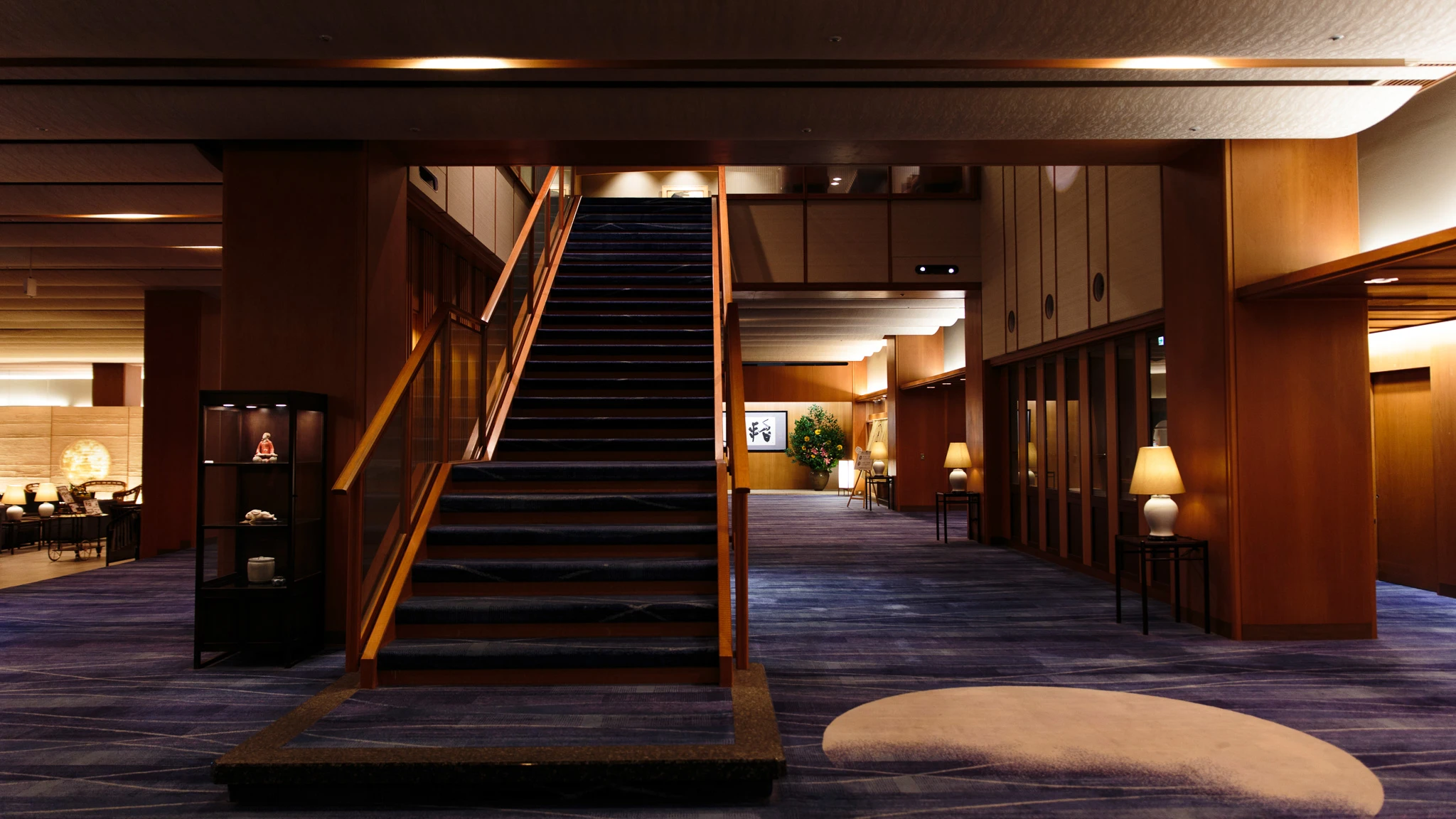 Ryokan lobby with a broad staircase and warm lighting