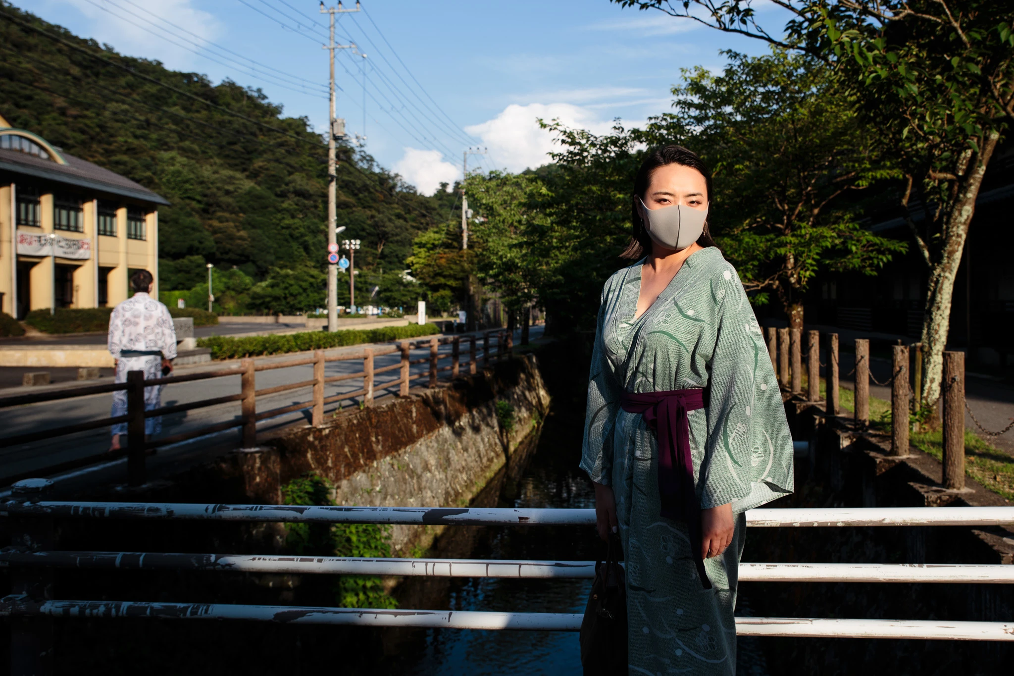 Visitor in a yukata standing beside a canal