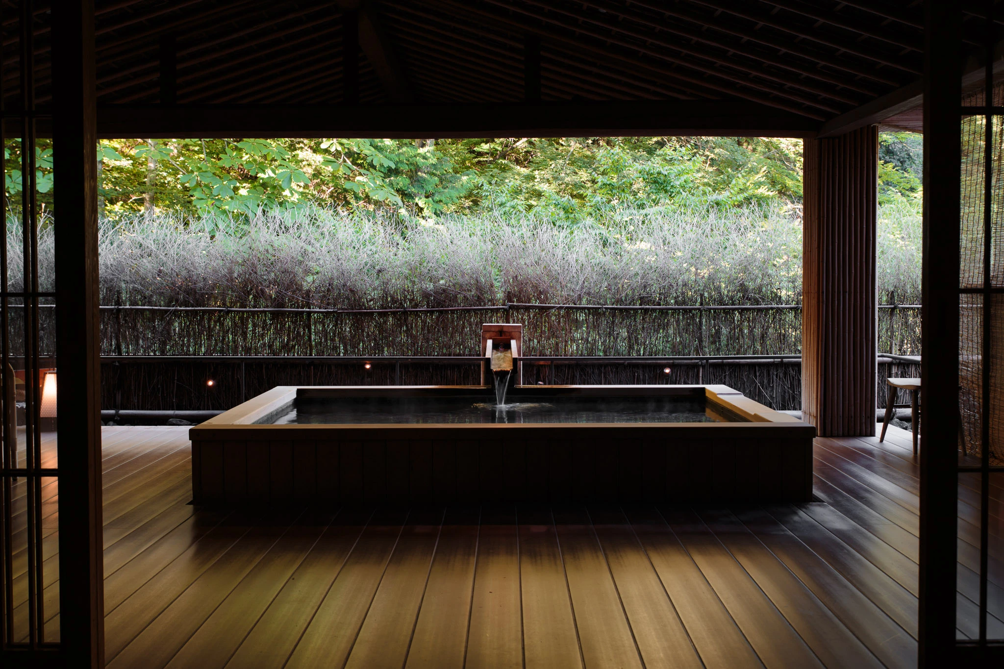 Timber-lined outdoor bath overlooking greenery