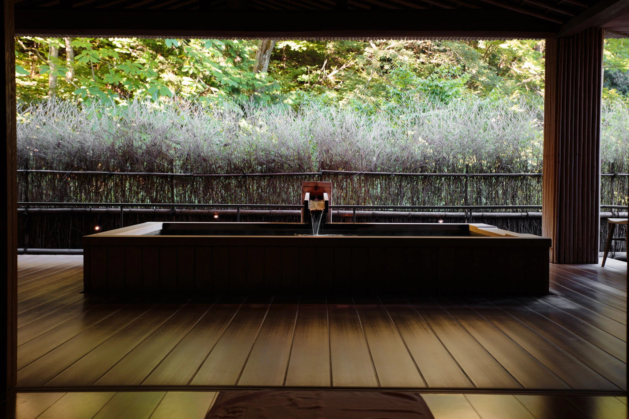 Outdoor bathing area framed by bamboo and greenery
