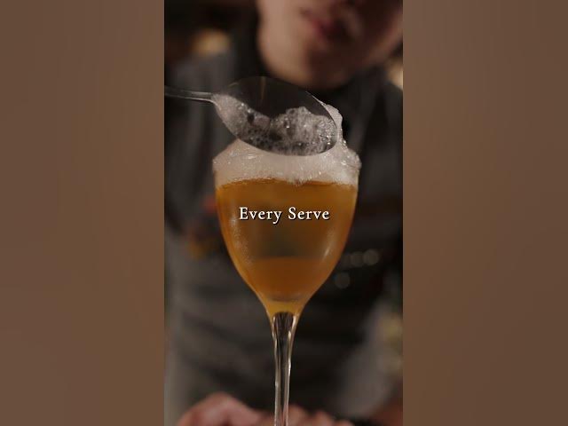 A Moonwell bartender pours a cocktail into a stemmed glass