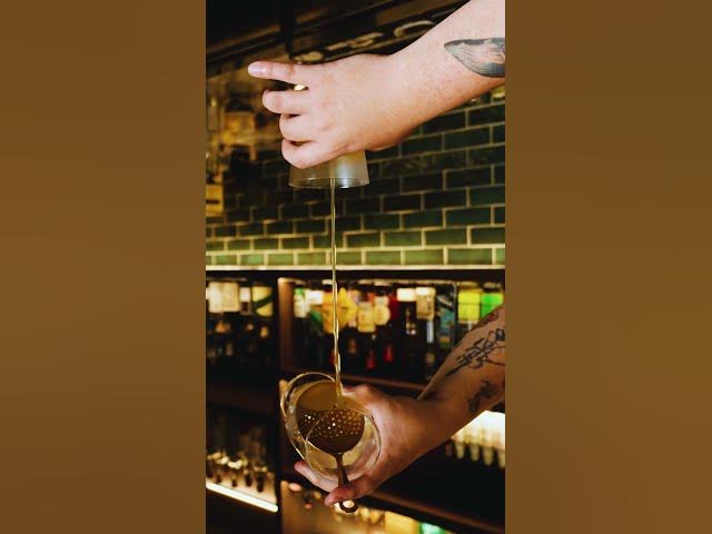 Hands and bar tools pouring a cocktail at Moonwell／Moonwell 吧台上以器具倒酒的手部特寫