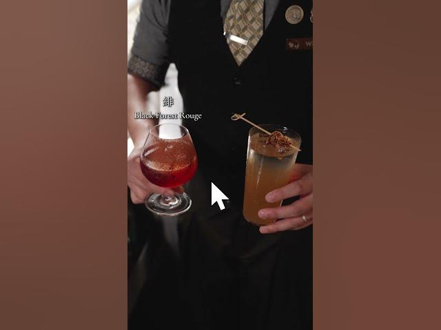 A Moonwell bartender holding two cocktails